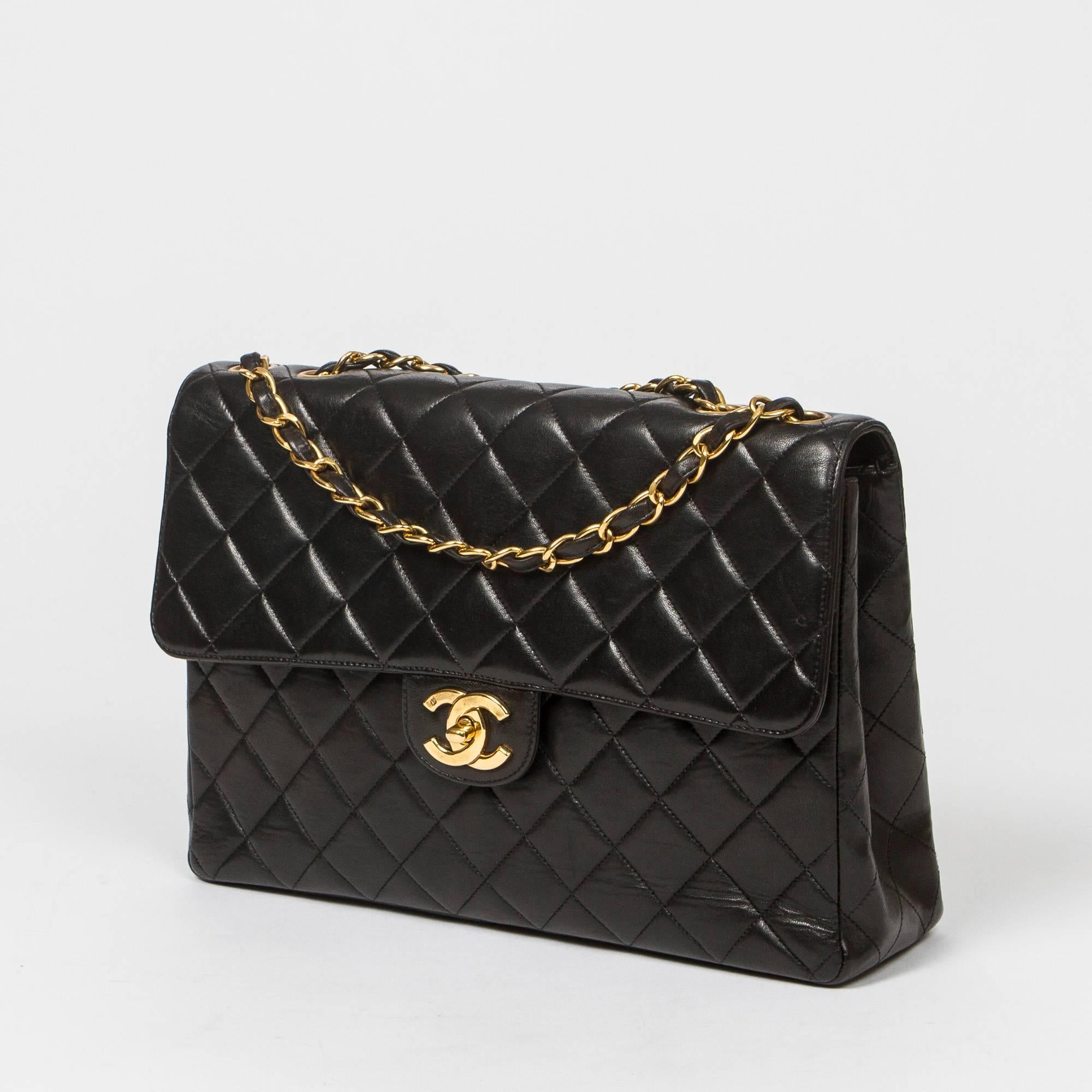 Jumbo in black quilted lambskin with double chain strap interlaced with black leather, signature CC turnlock, gold tone hardware.  Back slip pocket. Burgundy leather lined interior with one slip pocket and one zip pocket. Gold tone heat stamp