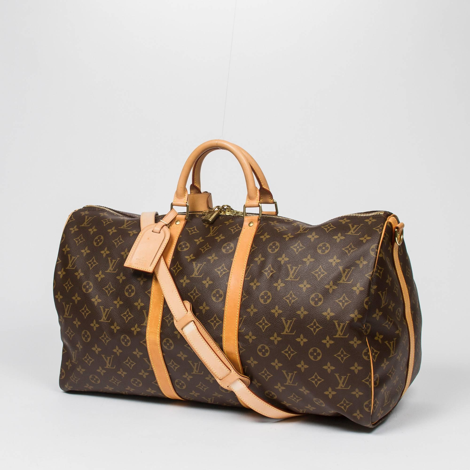 Keepall Bandouliere 55 in monogram canvas, vachetta leather shoulder strap handles and trimmings. Golden brass hardware. Double zipper closure. Brown canvas lining. Luggage tag, handle strap, cadenas and keys included. Date code MB0011. Model from
