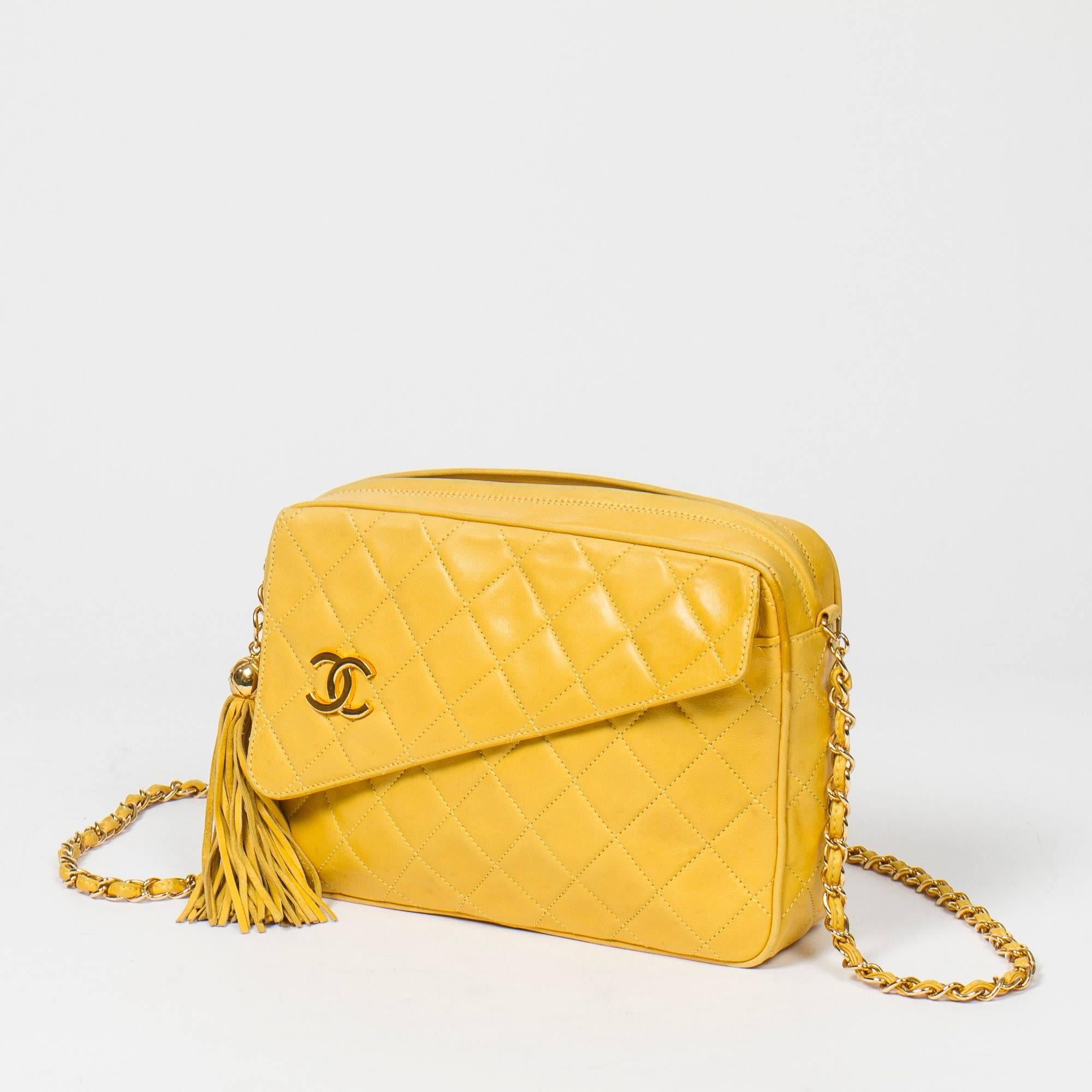 Vintage shoulder bag in yellow leather with chain strap interlaced with leather, front pocket with CC and magnetic closure on flap. Zip closure with leather tassel zipper toggle. Black leather interior with one slip pocket and one zip pocket.
