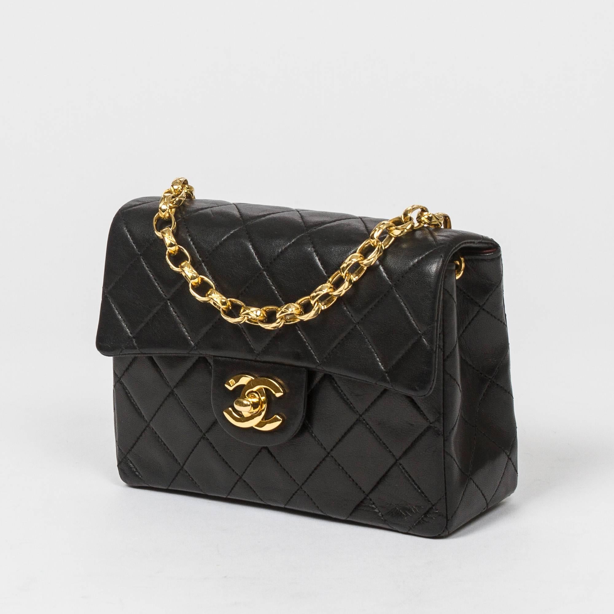 Classic Mini Flap 17cm in black quilted lambskin with thick link chain strap, gold tone CC turnlock. Back slip pocket. Burgundy leather lined interior with one slip and one zip pocket. Gold tone 