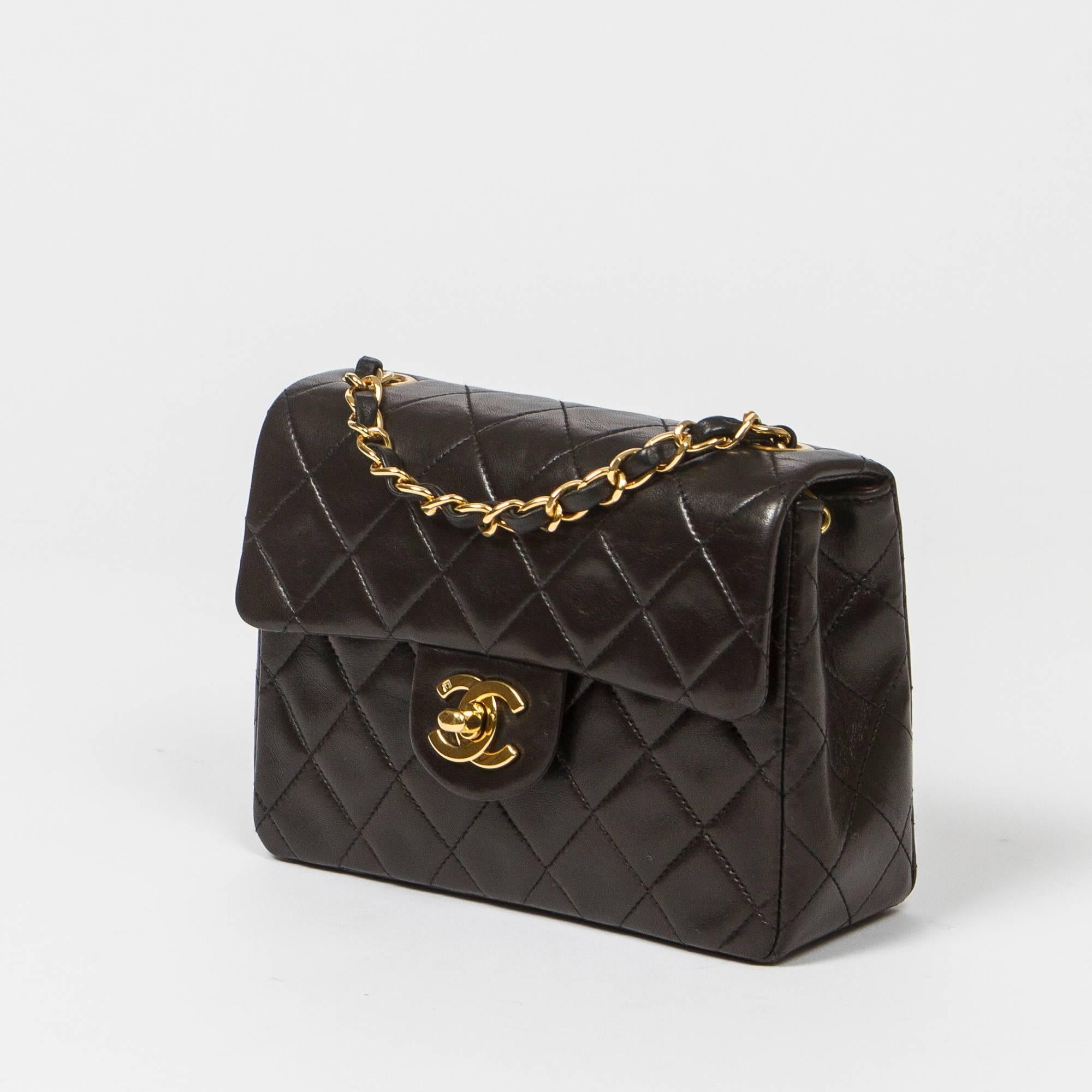 Classic Mini Flap 17cm in black quilted lambskin with chain strap interlaced with leather, gold tone CC turnlock. Back slip pocket. Burgundy leather lined interior with one slip and one zip pocket. Gold tone 