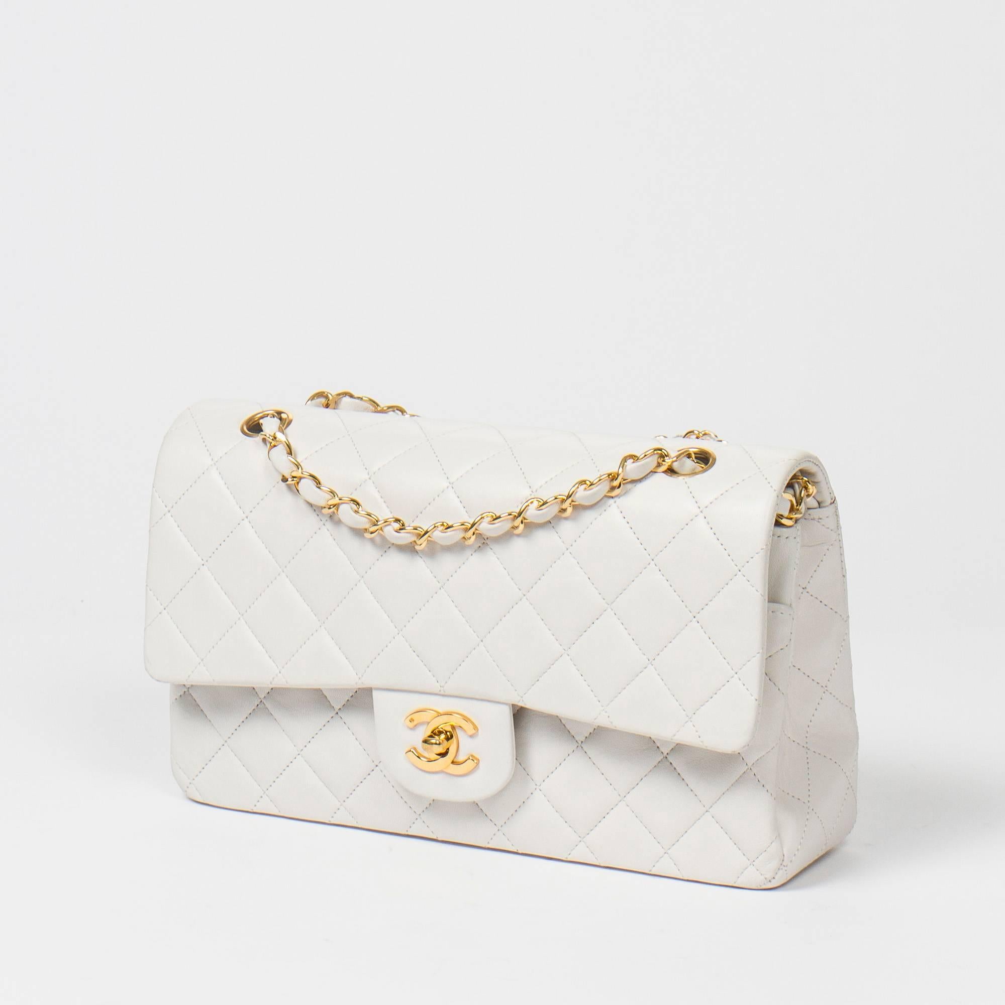 Classic Double Flap 26cm in white quilted lambskin, double chain strap interlaced with leather, signature turnlock closure, gold tone hardware. Back slip pocket. White  leather lined interior with 3 slip pockets. Gold tone heat stamp 