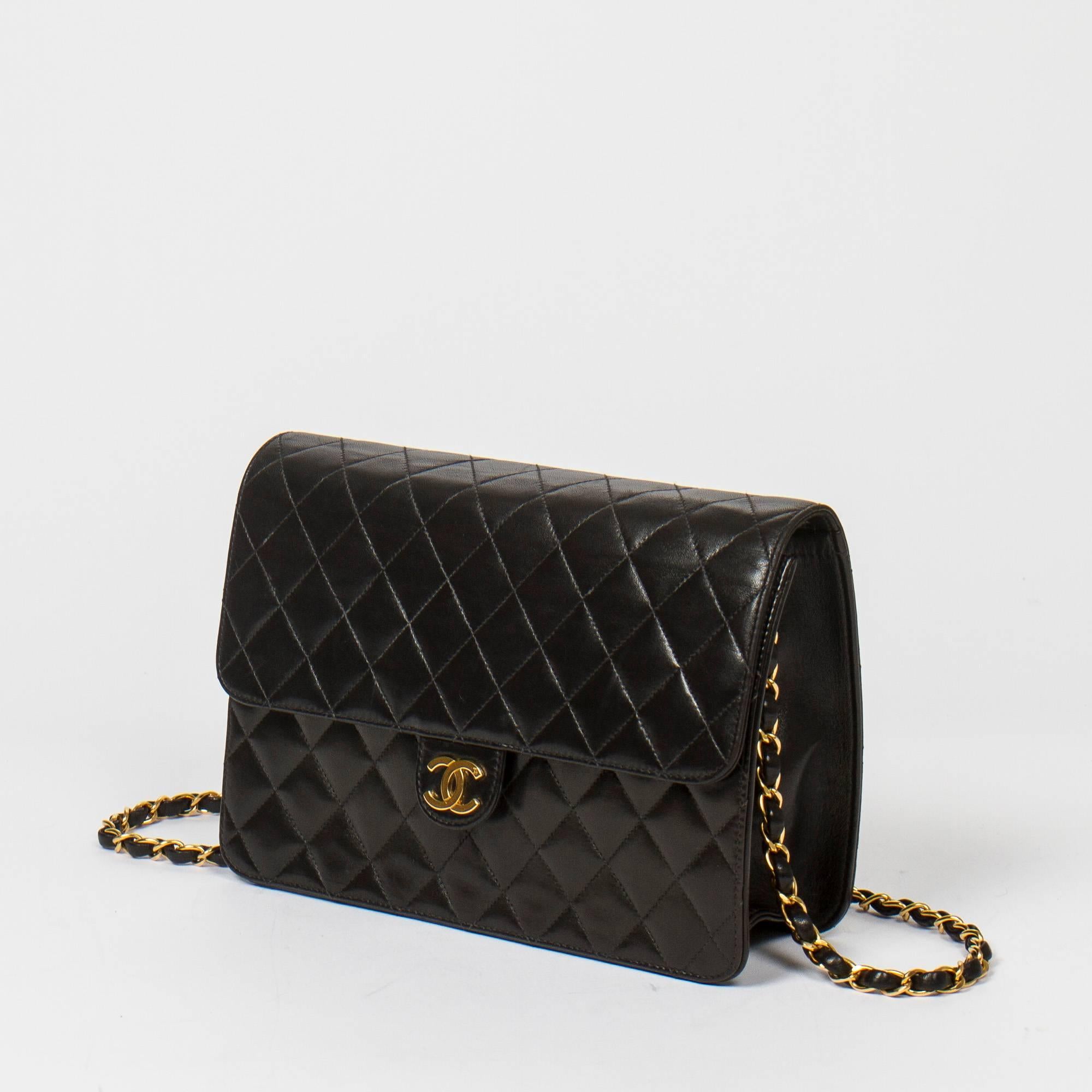 Vintage Mademoiselle Pochette shoulder bag in black quilted lambskin with gold tone chain strap interlaced with black leather. Gold tone CC press closure. Burgundy lined interior with one zip pocket. Gold tone heat stamp 