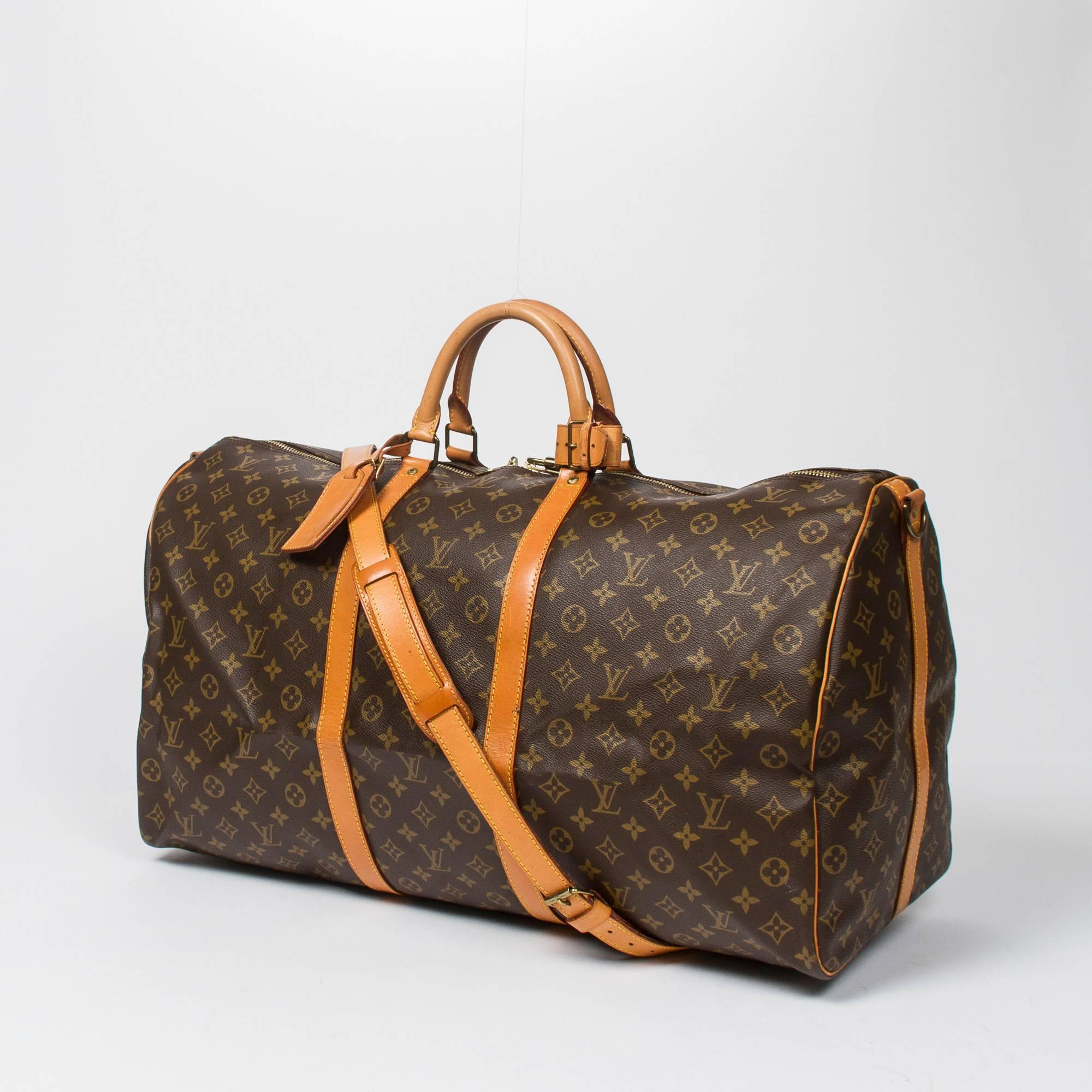 Keepall Bandouliere 60 in monogram canvas, vachetta leather shoulder strap handles and trimmings. Golden brass hardware. Double zipper closure. Brown canvas lining. Luggage tag, handle strap, cadenas no key included. Date code VI0941. Model from