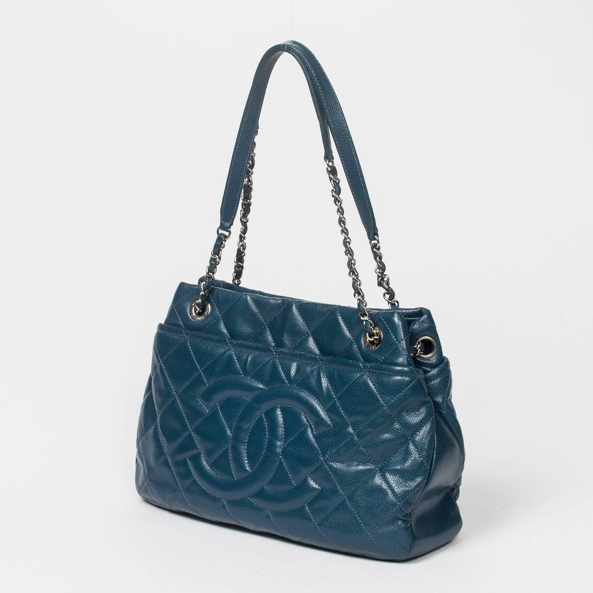Shoulder Tote Front Logo in blue caviar quilted leather, double chain strap interlaced with leather, silver tone hardware. Back and front slip pockets. Ivory leather lined interior with 2 slip pockets and 1 zip pocket. Gold tone heat stamp 