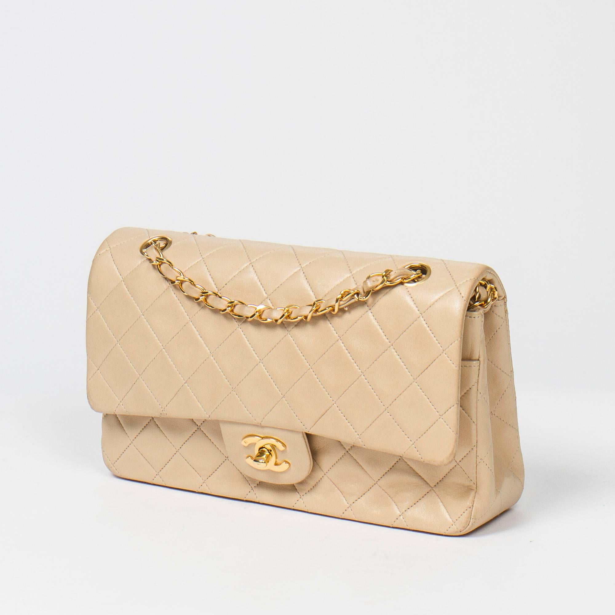 Classic Double Flap 26 in beige quilted calf leather, double chain strap interlaced with leather, signature turnlock closure, gold tone hardware. Back slip pocket. Beige leather lined interior with 3 slip pockets. Gold tone heat stamp 