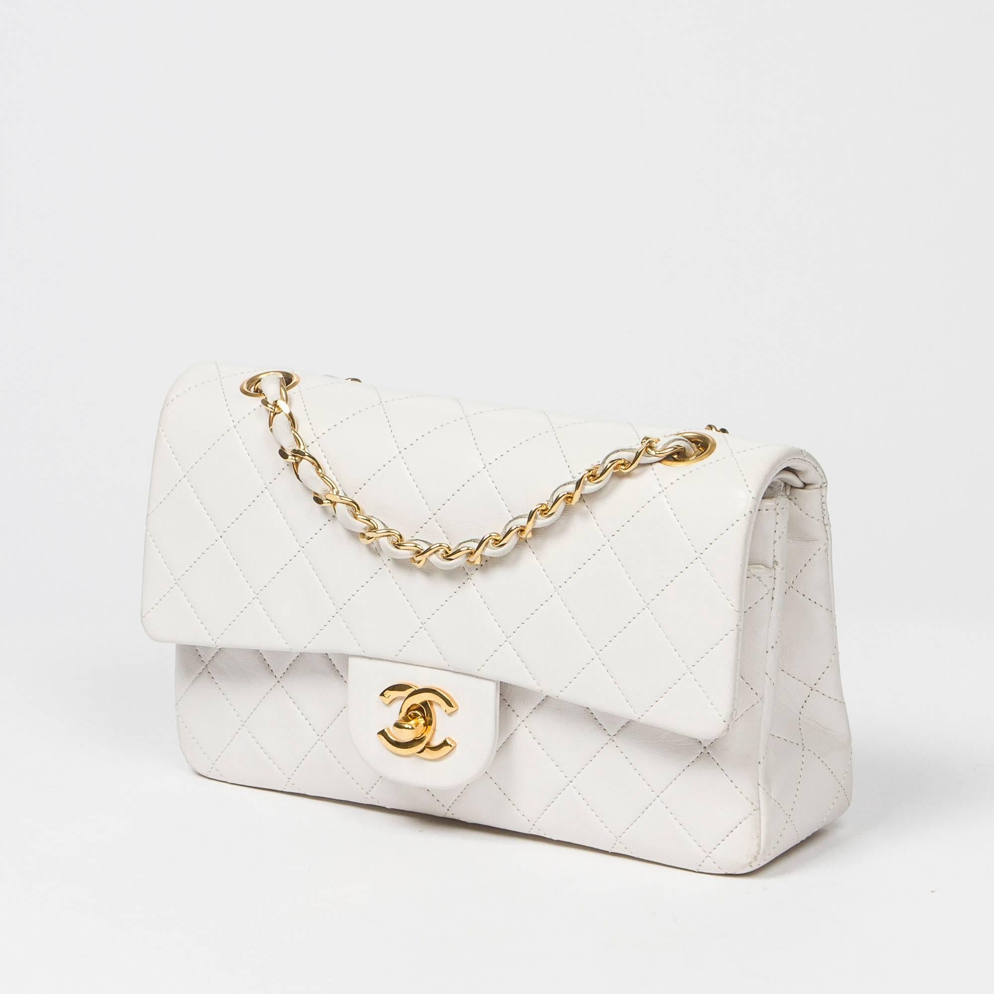Classic Double Flap in white quilted calf leather, double chain strap interlaced with leather, signature turnlock closure, gold tone hardware. Back slip pocket. White leather lined interior with 3 slip pockets. Gold tone heat stamp 