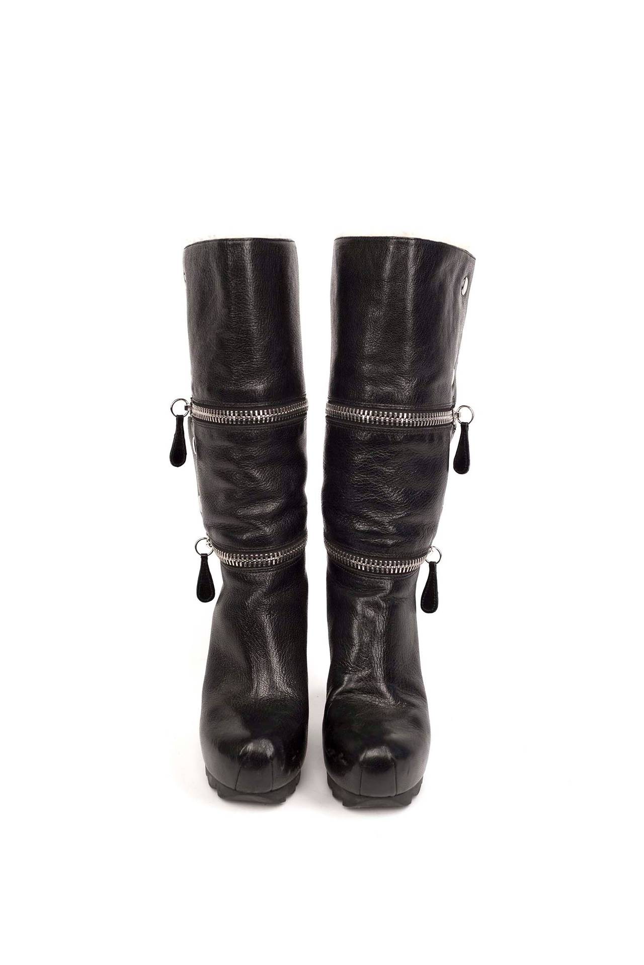 Camilla Skovgaard zippered platform wedge.
 Pebbled leather ankle-high wedge boots in black. rounded toe. Silver tone double exposed zip enclosure. Silver tone press studs at side. Signature tags at zips. Wool lining. Rubber sole. Approx. 4.75