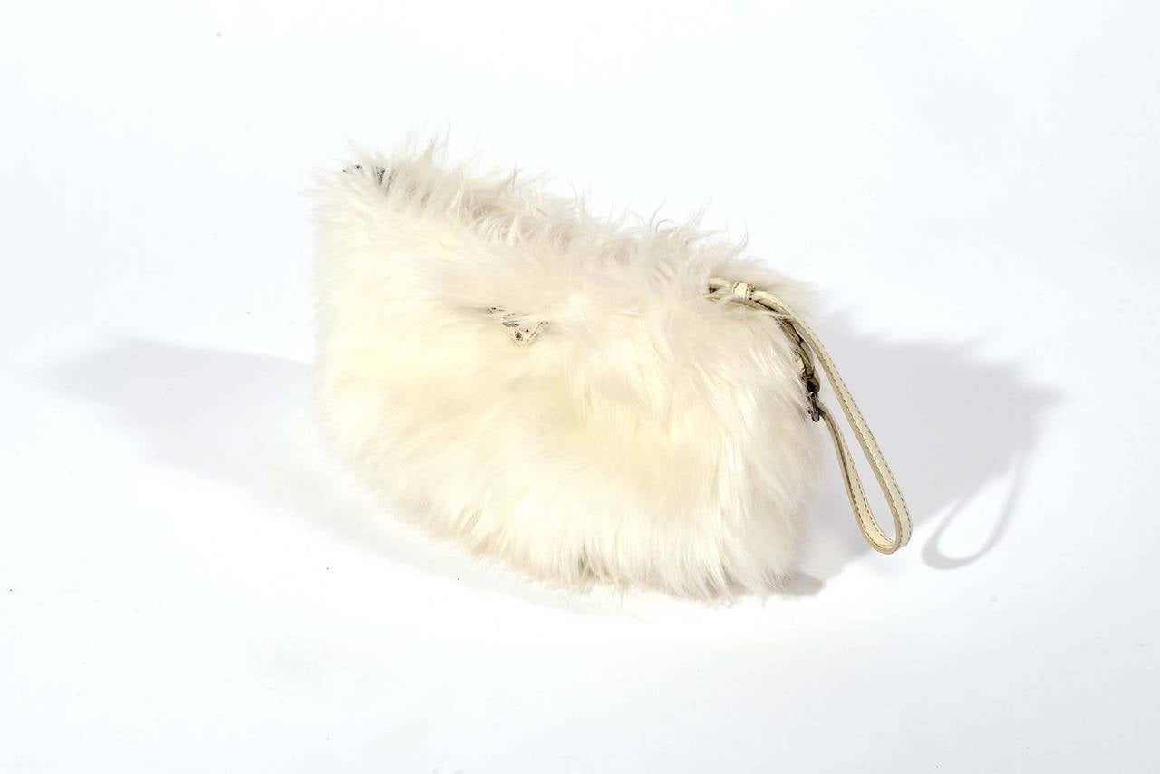 Prada White Faux Fur Clutch Bag. This stunning bag features fluffy and soft faux fur, a easy to use zip to closure and convenient leather wristlet. This ultra unique clutch is a classic shape and is perfect for any night time event during the cold