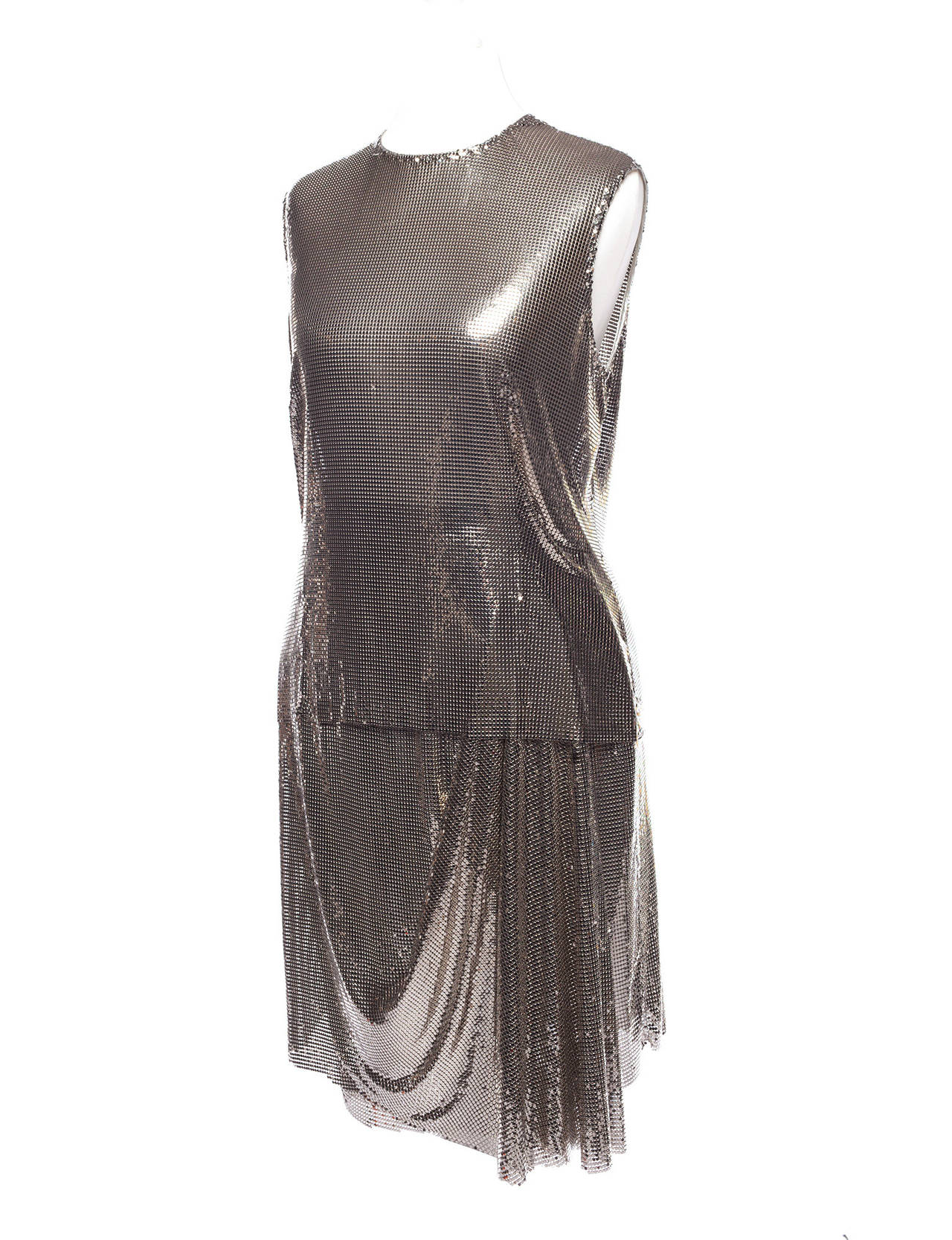 Gianni Versace vintage silver metal mesh outfit. Outfit comes in 2 seperate pieces, top is drapped metal mesh, sleeveless, back zipper and hook and eye, fully lined, skirt is drapped in front , side zipper with built in waist band, fully lined. This