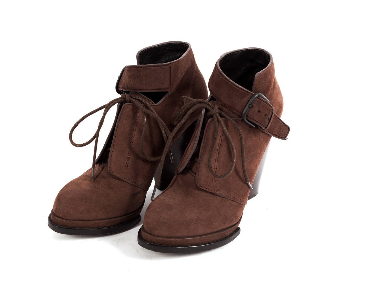 Plateau has multi details, shoe laces, front side strap with buckle and large oversized wooden heel.