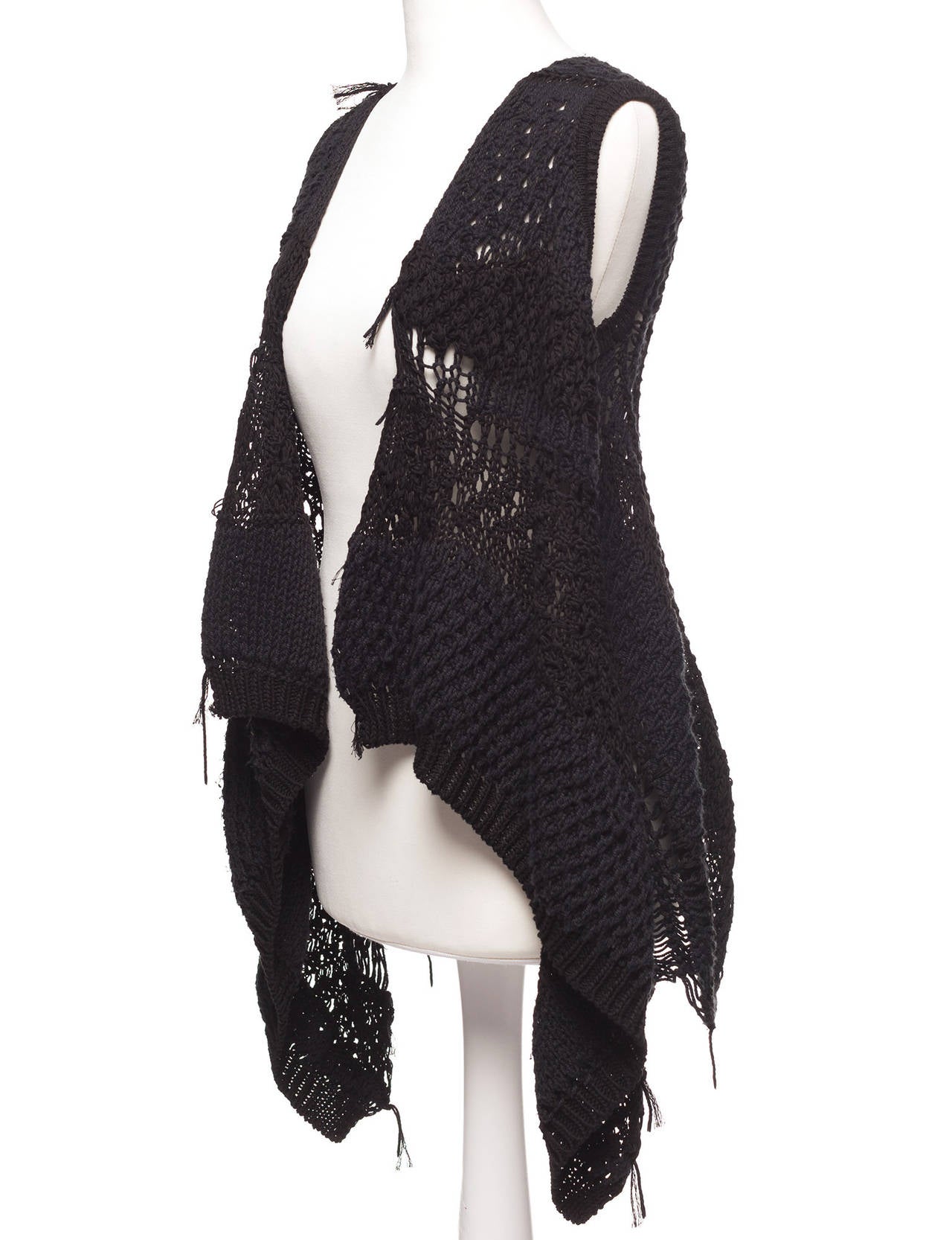 Vest is open crochet with draped asymmetric front, shorter in back bodice. The knit is an open weave.