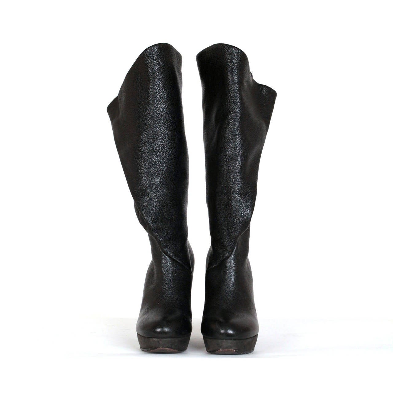 Balenciaga by Nicolas Ghesquière Plateau boots. Boots are black pebble leather, with fold detail at upper back side. Boots come just below knee and can be worn in a few options, snap detail for closure and have soft suede covering the plateau. Made