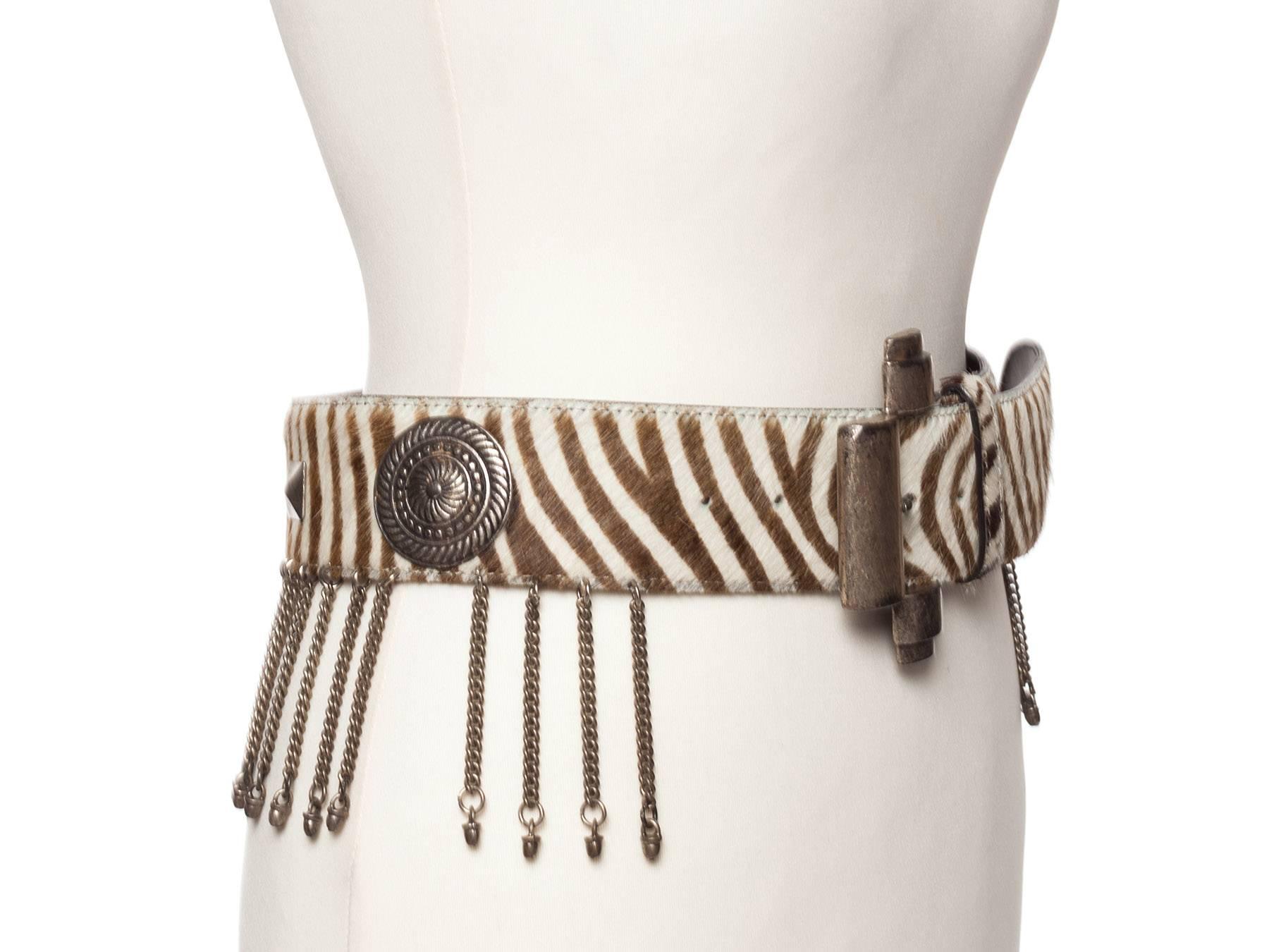 Belt has large grommets and metal fringe trim make this cool belt cooler and is a reminder of all things ethnic and glorious from Rifat Ozbeks hey day in fashion history.