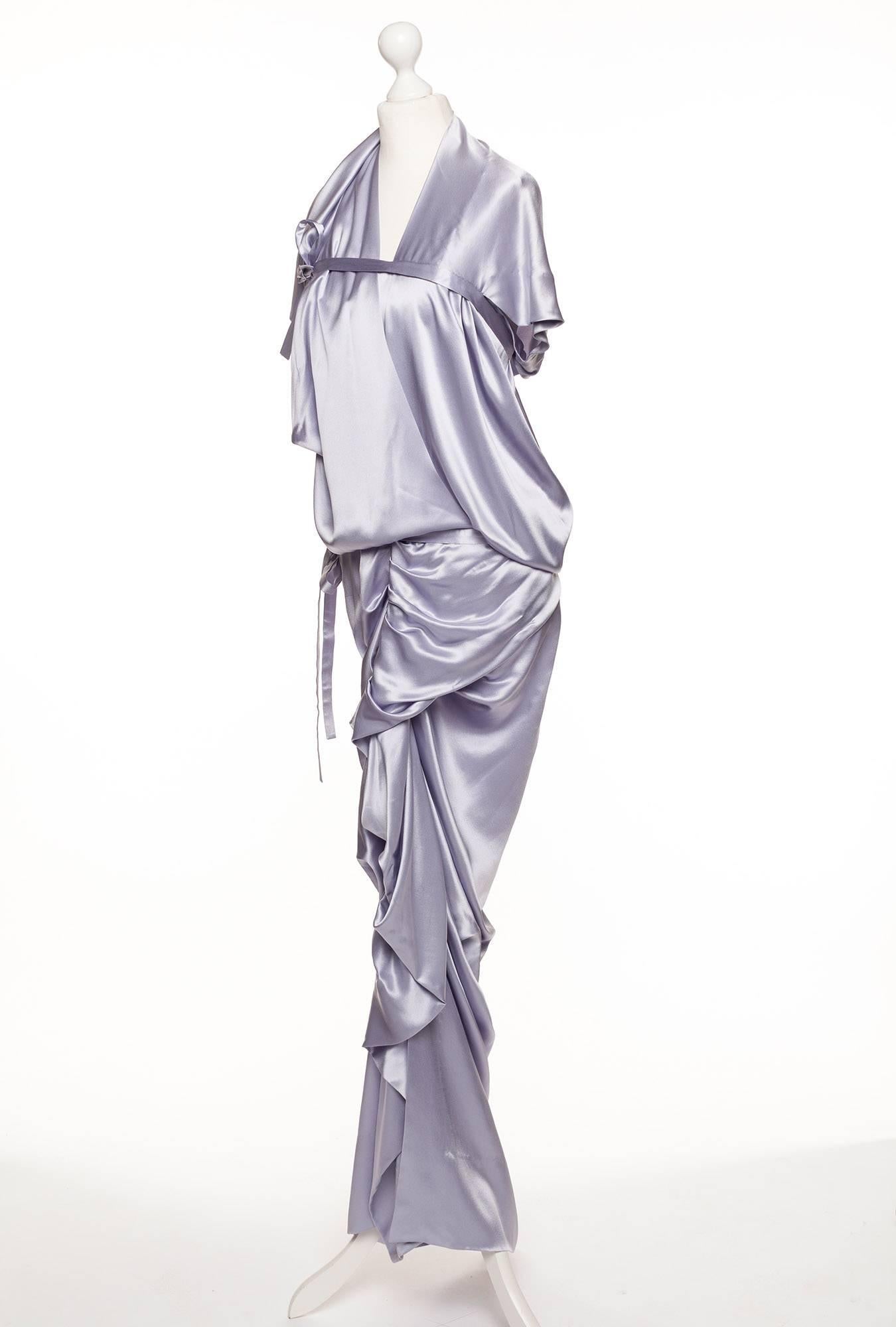 Dress has all the characteristics of a Westwood dress, designed with pure fantasy and shape in mind. Sleeveless with folded and draped fabric creating angular shapes, tie details gives the option to create different lengths and forms.  Perfect for a