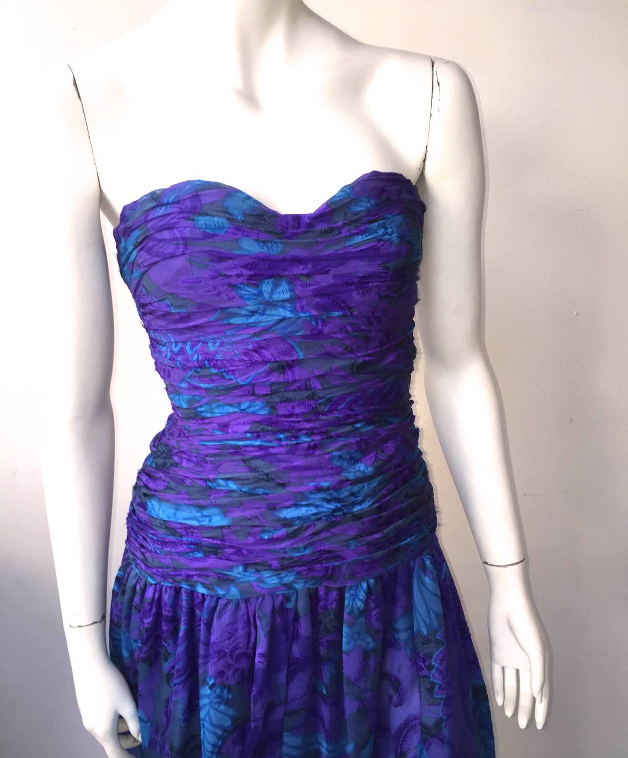 Carolyne Roehm 80s blue / purple silk strapless gown size 4. 
Bodice is ruche and skirt has sexy slit up front. 
Floral patterns with shades of blues & purples.
Bone corset inside as shown in photo.
Silk lining.
Made in USA.

Carolyne Roehm
