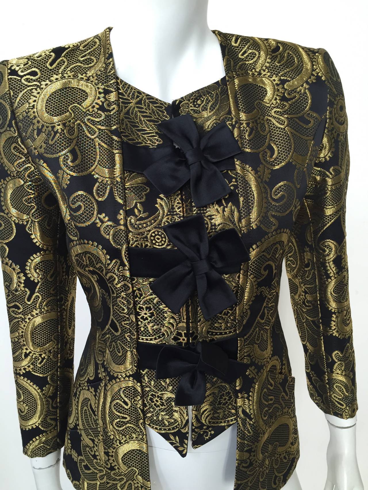 Christian Lacroix 80s gold brocade evening zipper jacket with 3 black bows and front pockets. Made in France size 36 or size 6 USA. Please see measurements.
This jacket would look amazing with your vintage YSL tuxedo pants.
Measurements are:
34