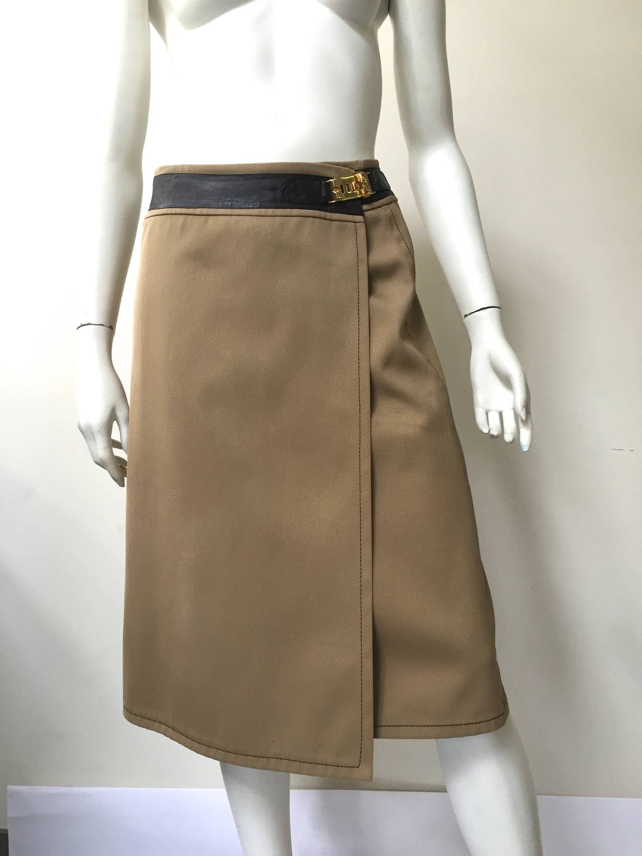 Celine 70s wrap skirt that is trimmed in chocolate brown leather with gold adjustable buckle. 
Made in Italy. 
There are 2 buttons inside for extra security. 
Size 46 but fits today modern size 6. 
 Please use the measurements below that I