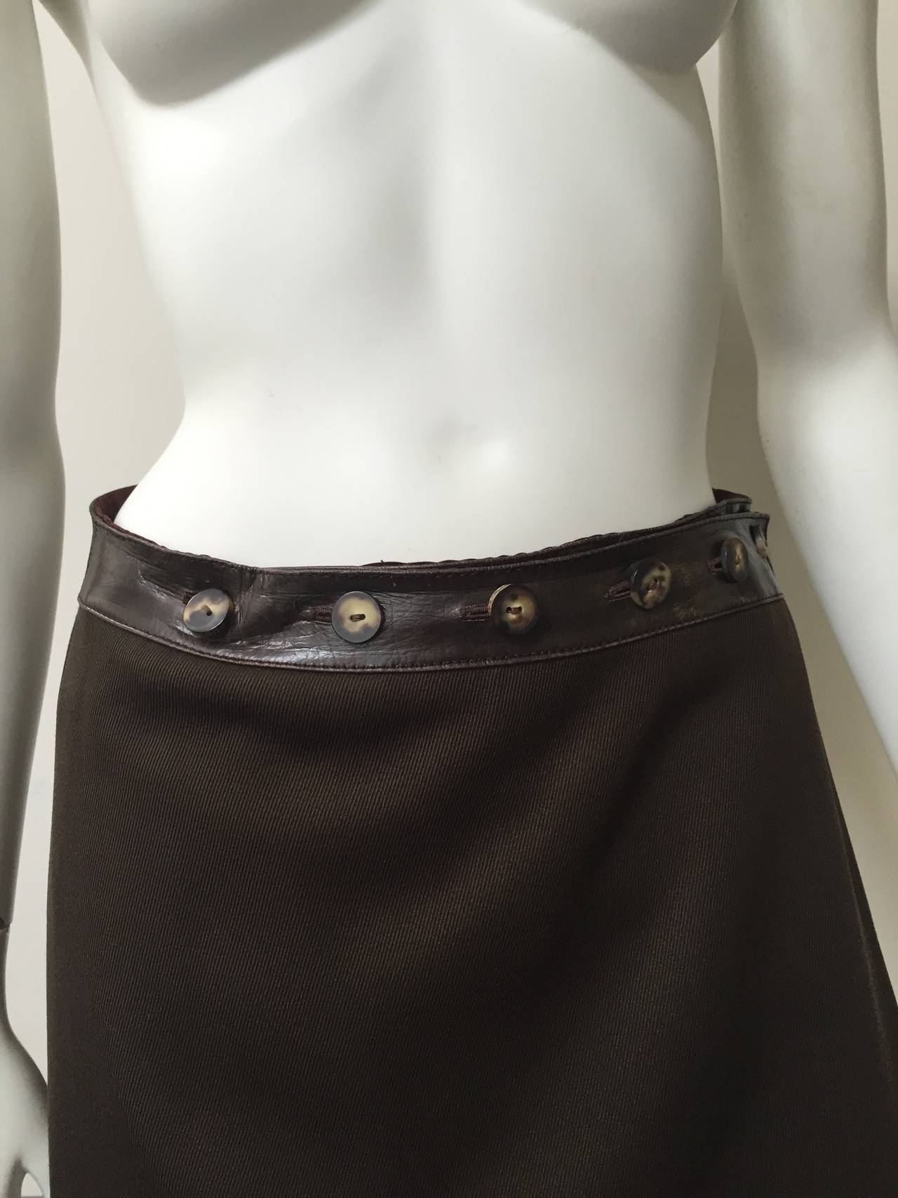 Celine 1970s wrap wool skirt with brown leather trim with 6 buttons size 6. 
Made in Italy.
Skirt is lined.
Measurements are:
28" waist
40" hips
25" skirt length.