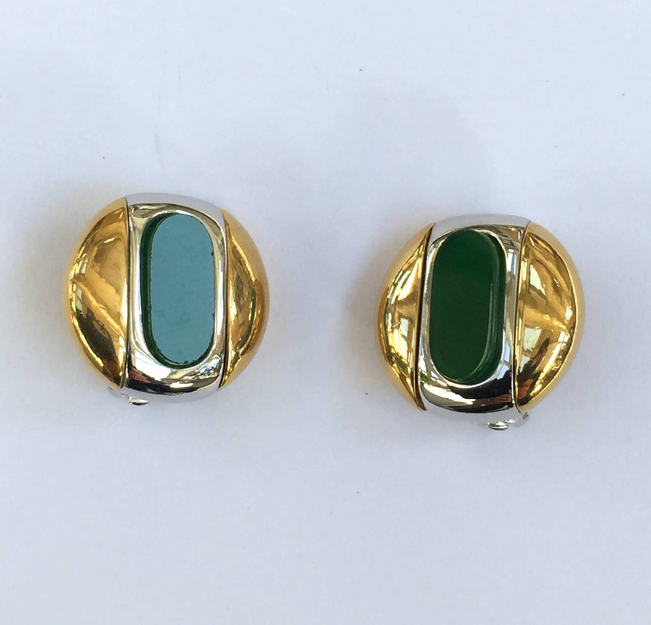 Givenchy 1977 gold / silver with green celluloid oval shape gives these clip earrings a modern design. 
1/2" diameter.