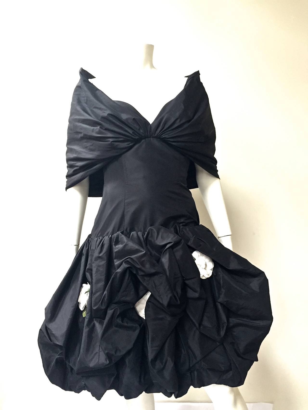 Bill Blass late 1980s silk taffeta with pouf bottom and camellia flowers strapless evening dress size 6 (please see measurements). 
Starting at bust and wrap around caplet with 2 snap buttons at back to hold caplet up and in place. Boned corset