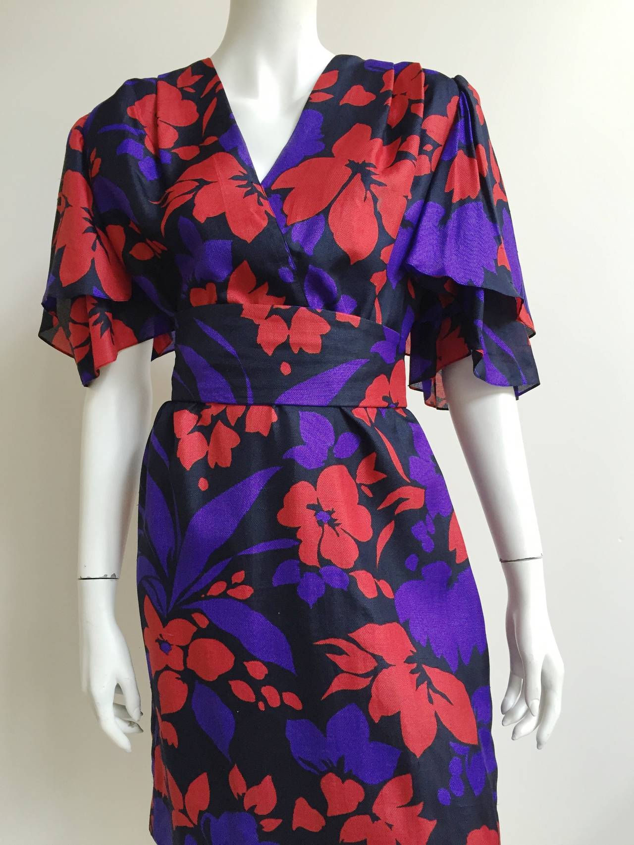 Givenchy Nouvelle Boutique early 1980s flower pattern dress with sash belt fits a size 12 but please see & use measurements. Layered sleeves and vibrant color palette makes this one eye catching dress.  Zipper on side.
Measurements are:
40