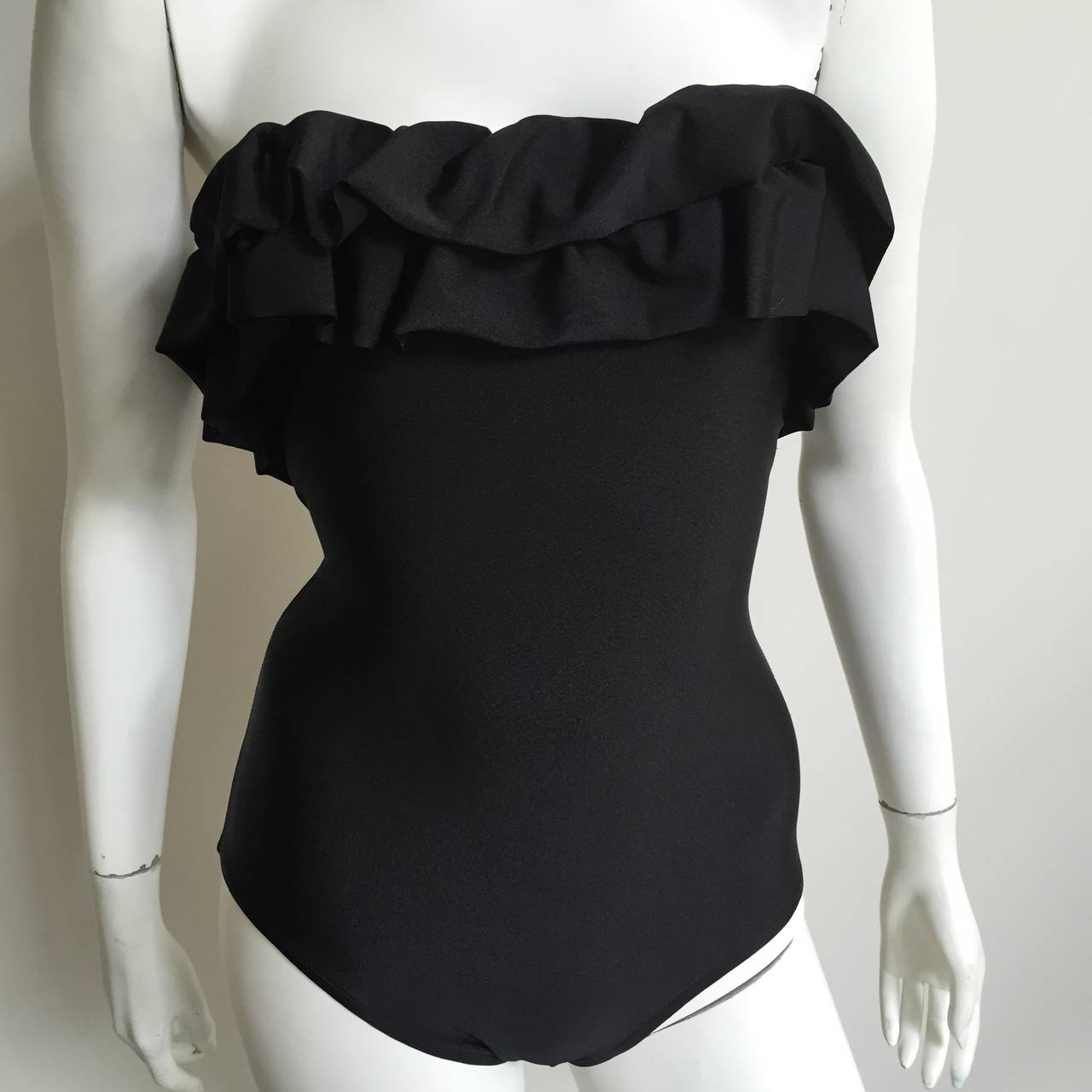 Bill Blass 1970s black ruffled one piece swimsuit original size 8 but fits like a modern size 4. Mannequin is a true size 4 and as you can see swimsuit fits to perfection. The strap that wraps around neck is missing as shown in photo with button but