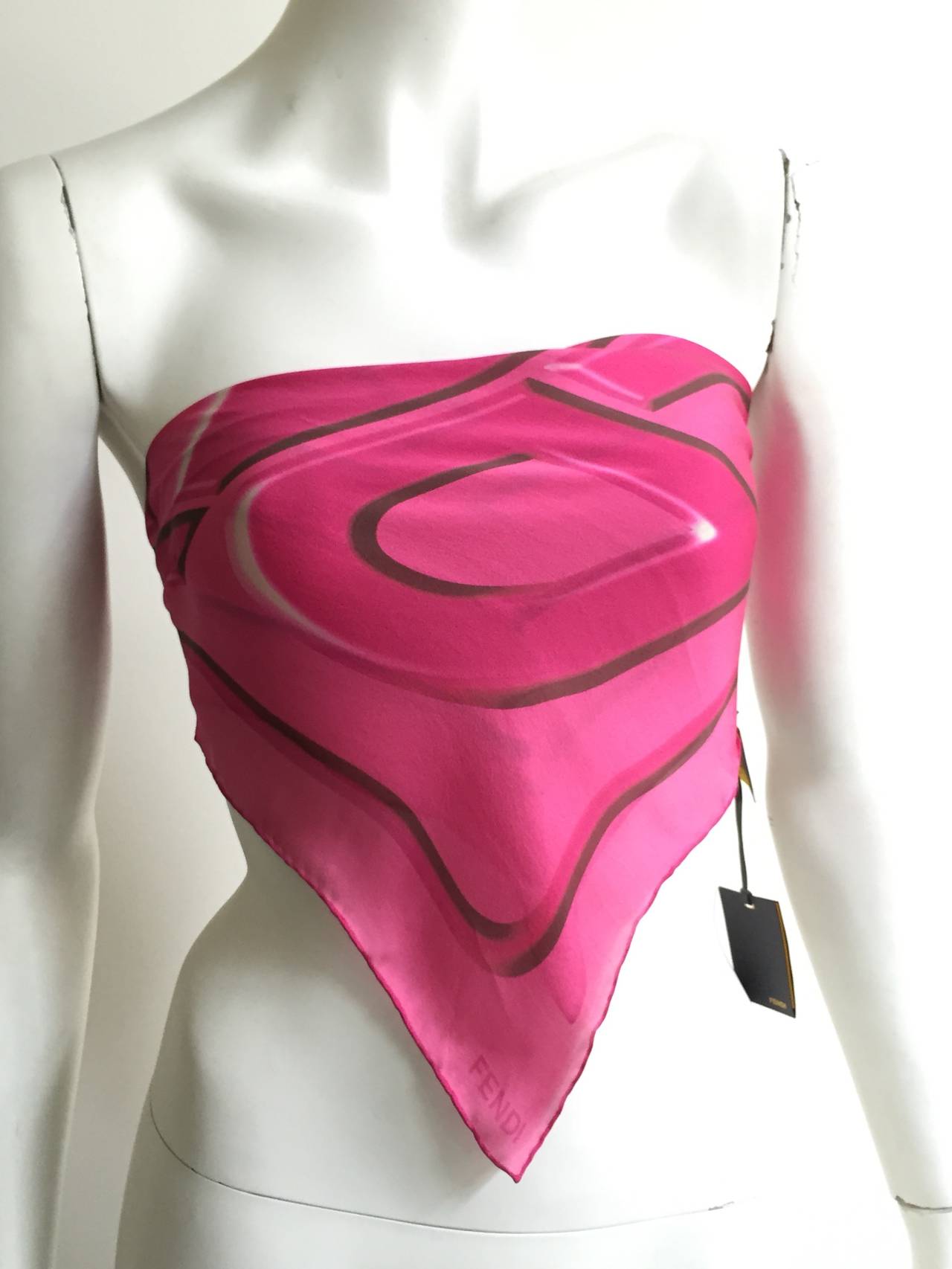 Fendi pink silk scarf still with original tags. Fun & modern print perfect for any occasion. This scarf never worn does have a water spot on it but other than that it's in perfect condition.  
22