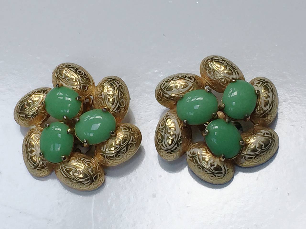 Elsa Schiaparelli 1960s gold with green glass center pieces clip earrings.
1.1/2