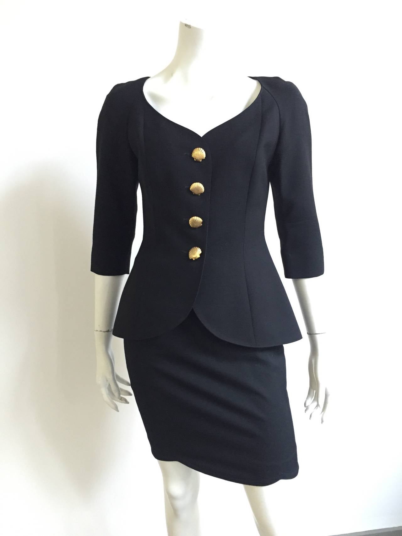 Lolita Lempicka Paris 1980s black wool skirt suit with gold shell buttons and 3/4 sleeves. Jacket and skirt lined.  Jacket has open dart on backside. 
Measurements are: Please use measurements to measure your body.
JACKET:
34.5