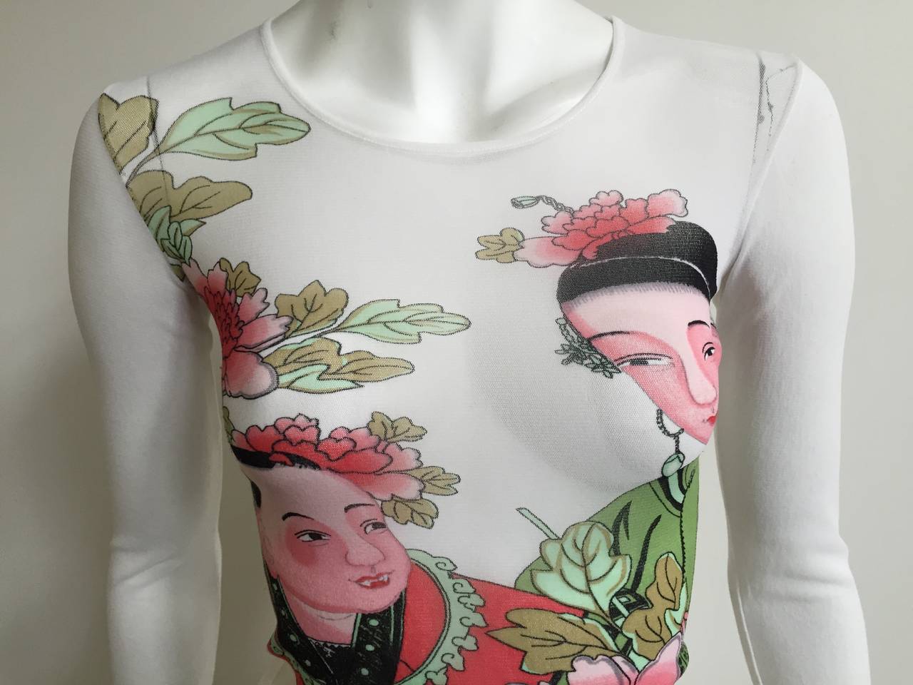 Kenzo Jungle Japanese couple sheer long sleeve top is a size small. The mannequin is a true size 4 and it fits her perfectly. Stretch netting fabric and simply gorgeous. 
Measurements are:
28.5" bust
21" sleeve length
19.5" top