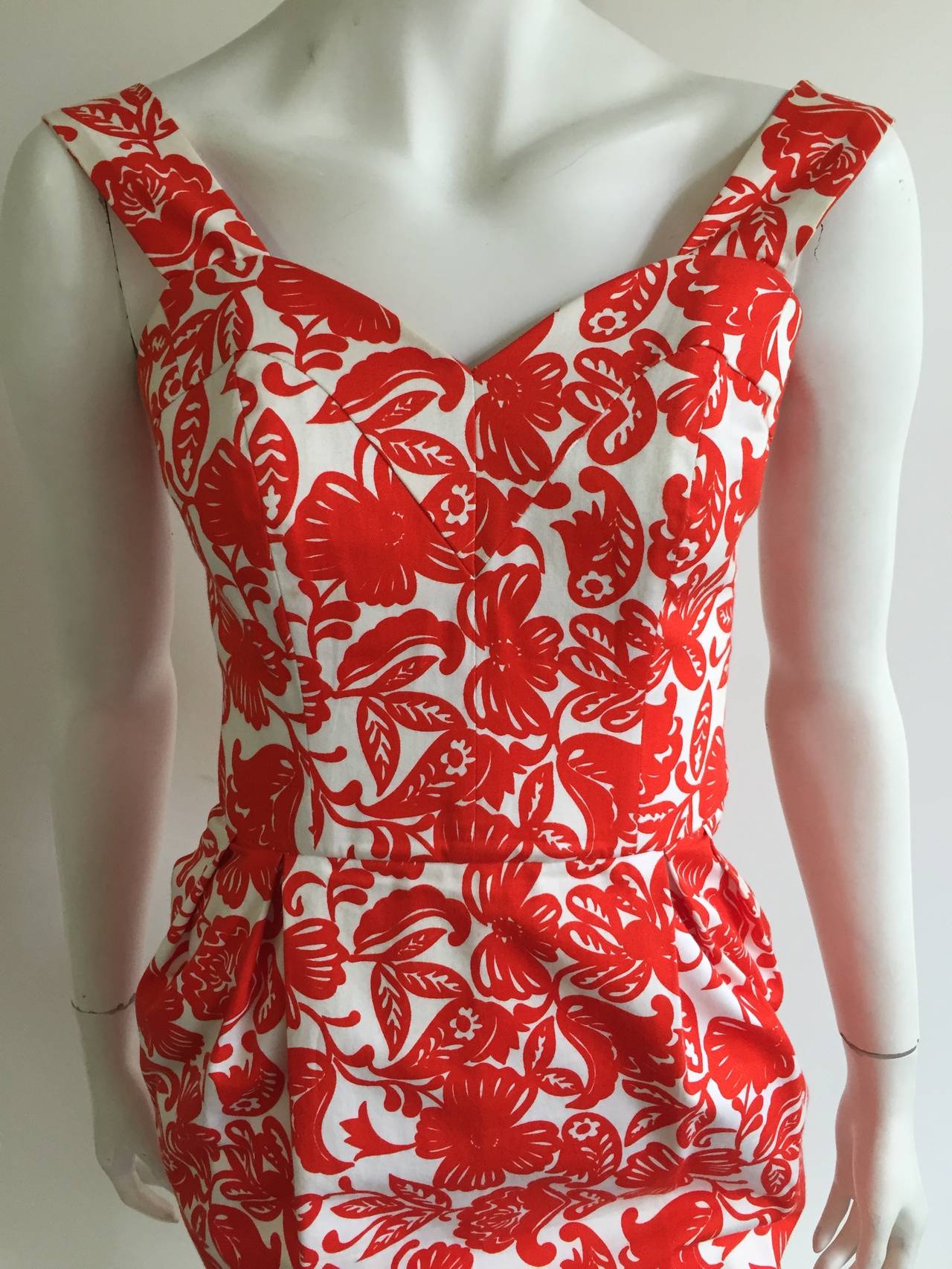 Nina Ricci 1996 red floral pattern cotton evening dress with pockets is a size 38 but fits like a modern size 6 ( Please see & use measurements so that you can properly measure your body). Interior acetate lining at bust area has slight yellowing