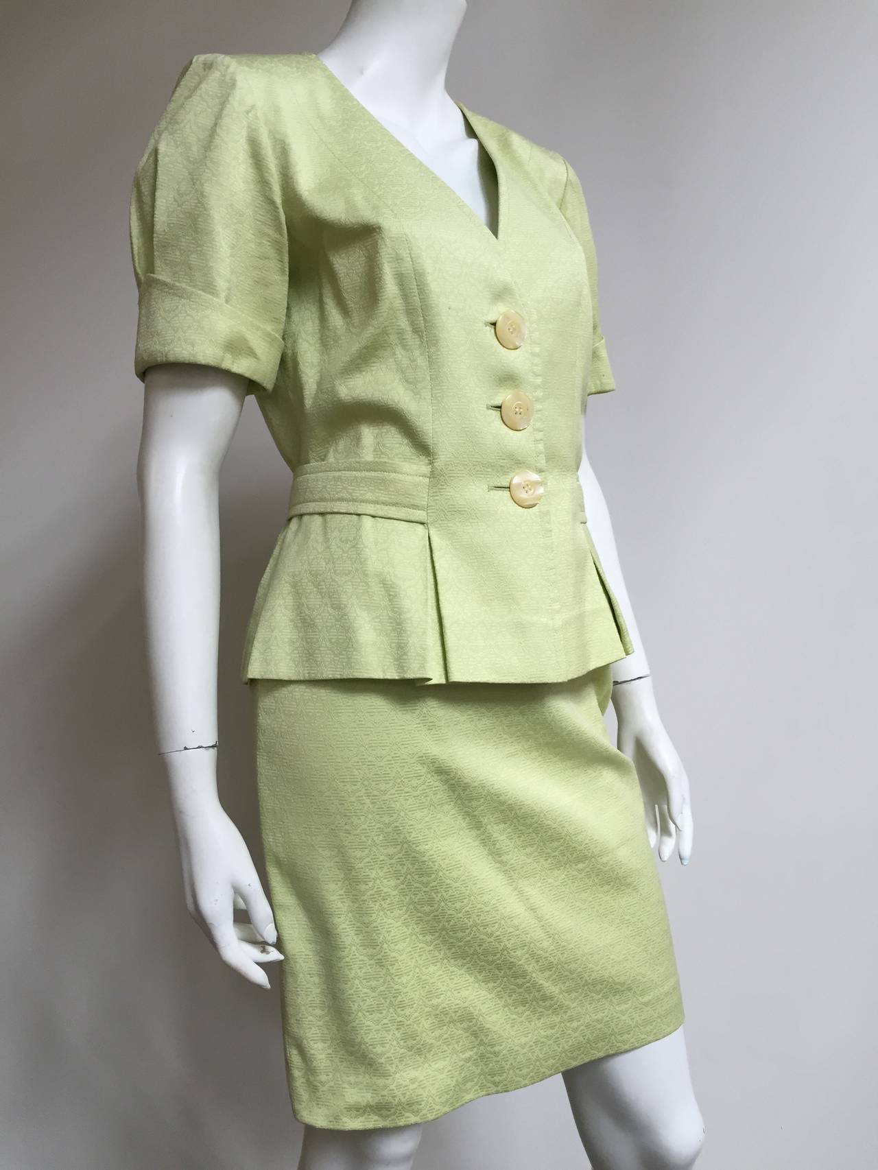 Yves Saint Laurent variation 1980s cotton skirt suit is a USA size 6.  Please see & use measurements provided. Celery color short sleeve three button jacket with front pockets that has button tie on back side. Skirt has side zipper. Made in France
