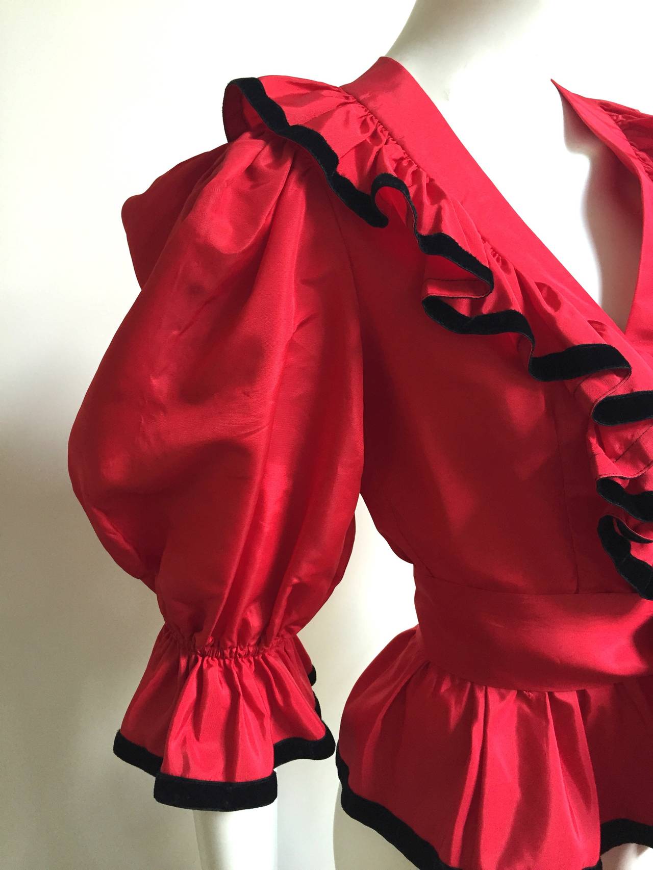 Albert Capraro 1970s red silk taffeta with black velvet trim and sash blouse size 4. Balloon sleeves and ruffled collar makes this blouse POP.
Measurements are:
32" bust
19" sleeves
15