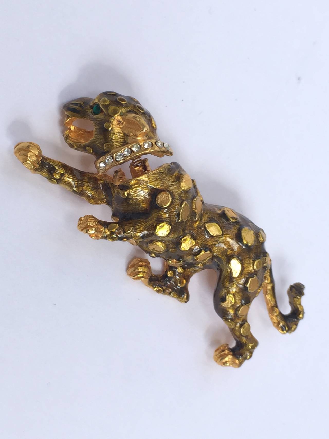 Hattie Carnegie 1960s brooch of a dog that head springs back and forth. Raised texture body with enamel rhinestone eye and clear crystals around collar. 
Measurements are:
2. 1/2