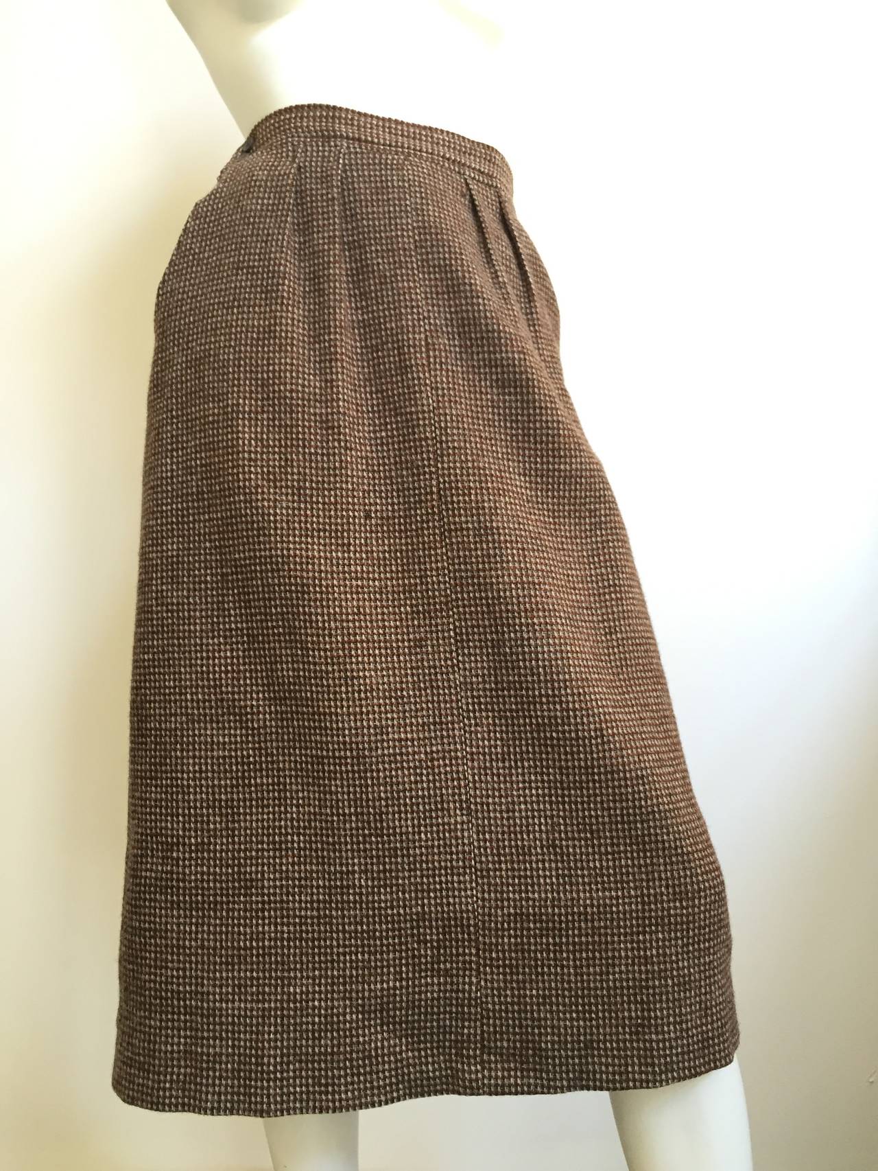 Yves Saint Laurent 1970s brown tweed skirt with pockets will fit a USA size 12. Please see & use measurements below to properly measure your waist and hips so you know this is exactly how YSL would have appreciated. Skirt is lined.
Measurements