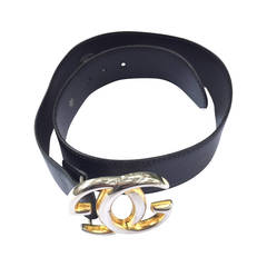 Gucci 'GG' logo buckle on black leather strap belt.