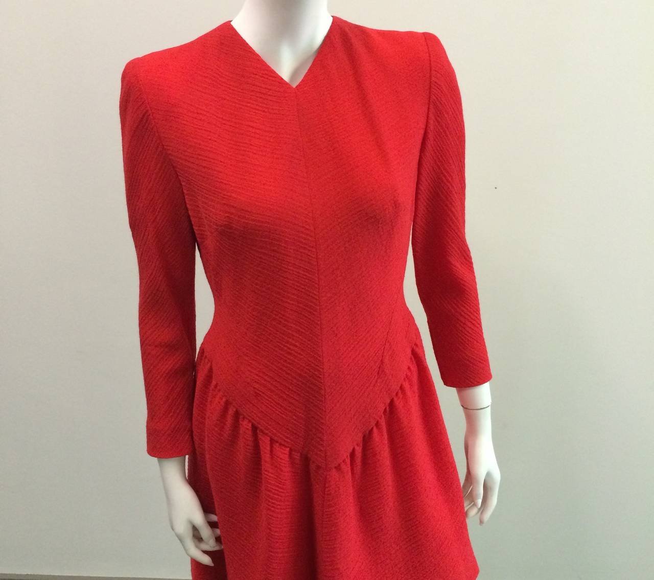 Pauline Trigere for Bergdorf Goodman 1980s red wool v neck short cocktail dress is a size 8 but is a modern day size 6.  The waist on this dress is 30