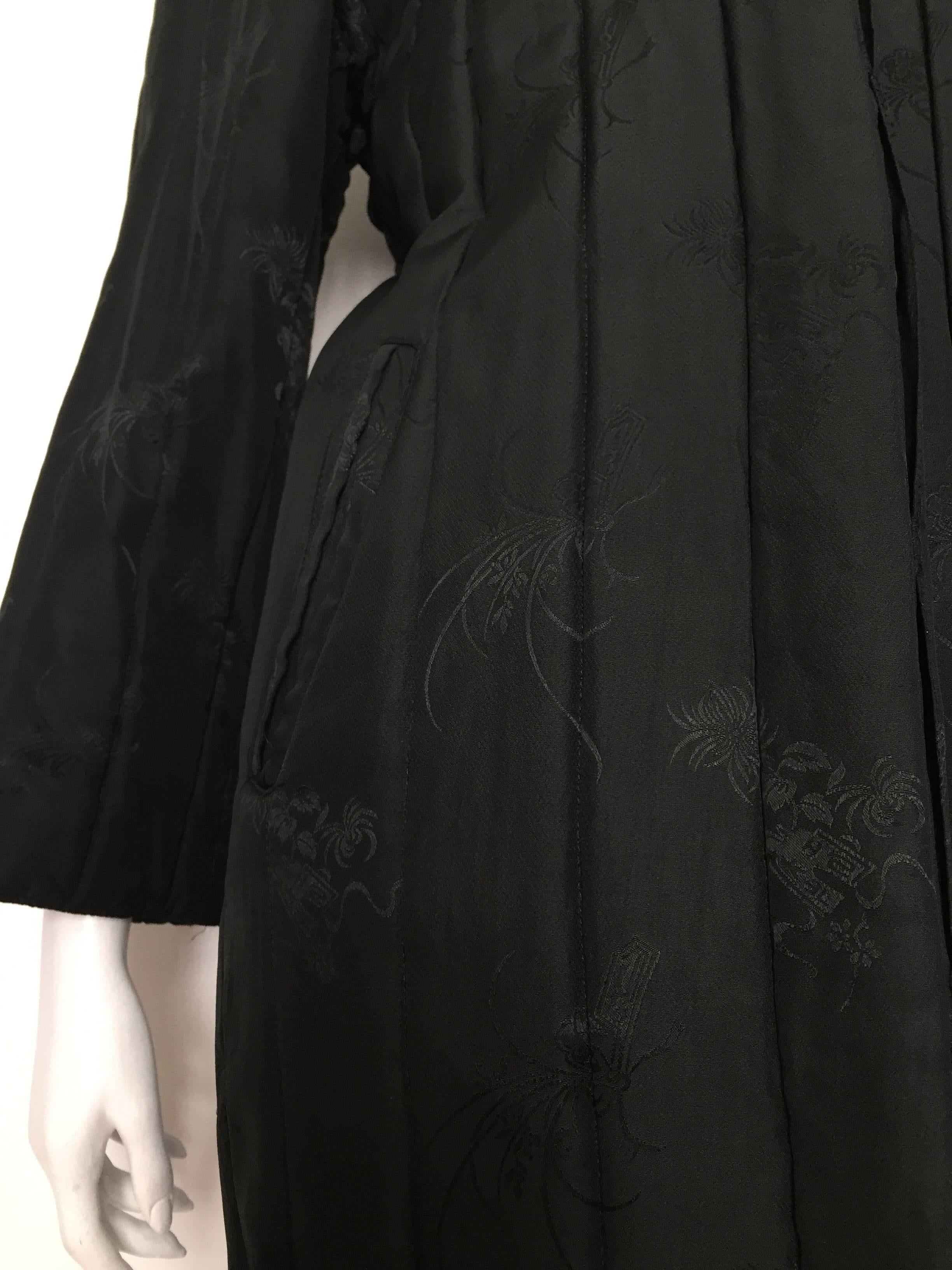 Bergdorf Goodman 1980s black silk, with lovely Asian pattern, long quilted coat that will fit a USA size 6 - 8 but please see the measurements below so you can properly measure your body to make certain this will fit your body. 
Measurements