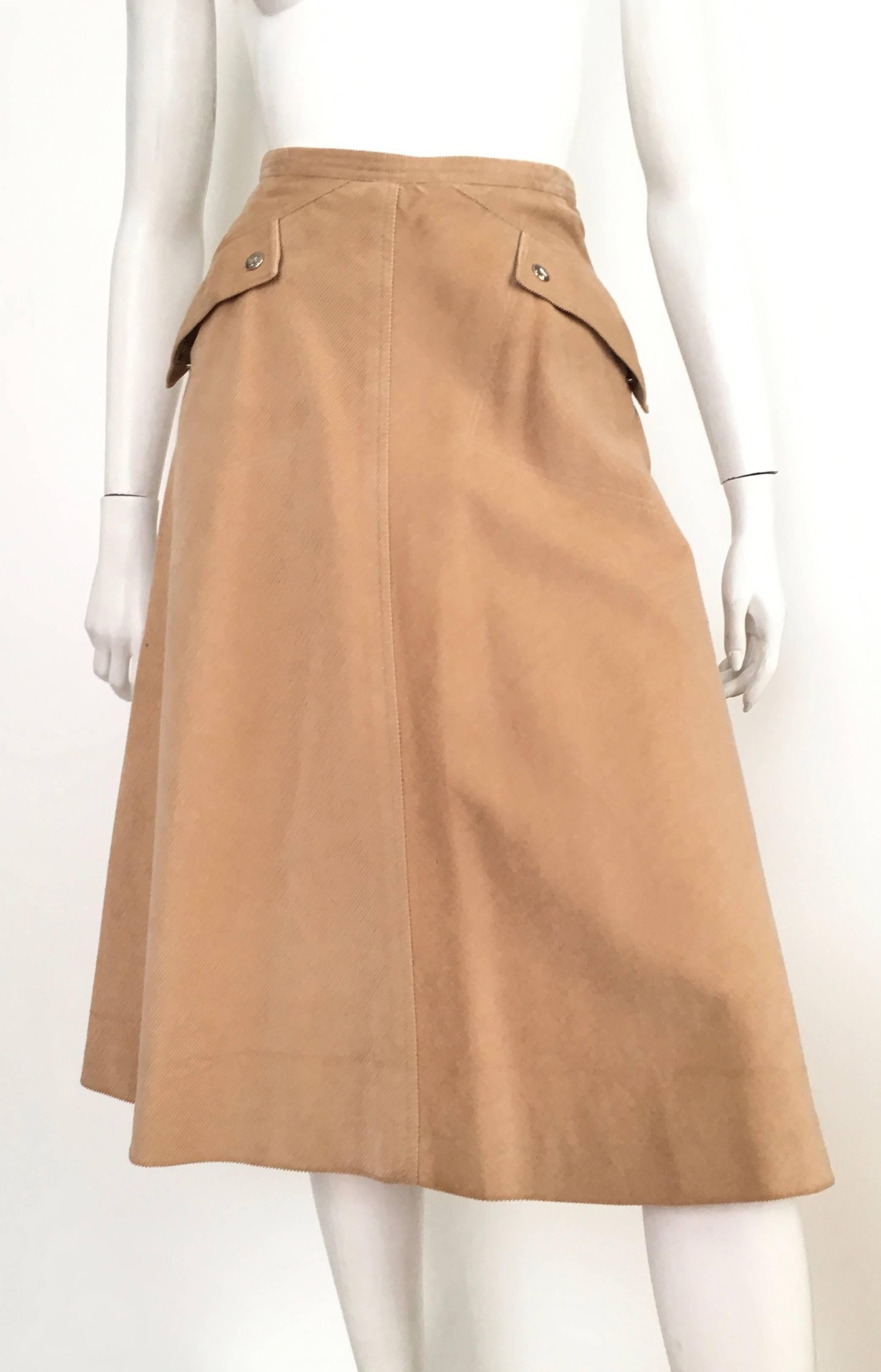 Courreges Paris khaki corduroy a-line two front pockets with logo snap buttons skirt is a size 4.  This fits Matilda the Mannequin perfectly and she is a true size 4, so if you and Matilda have the identical body then it's a green light.  Please use