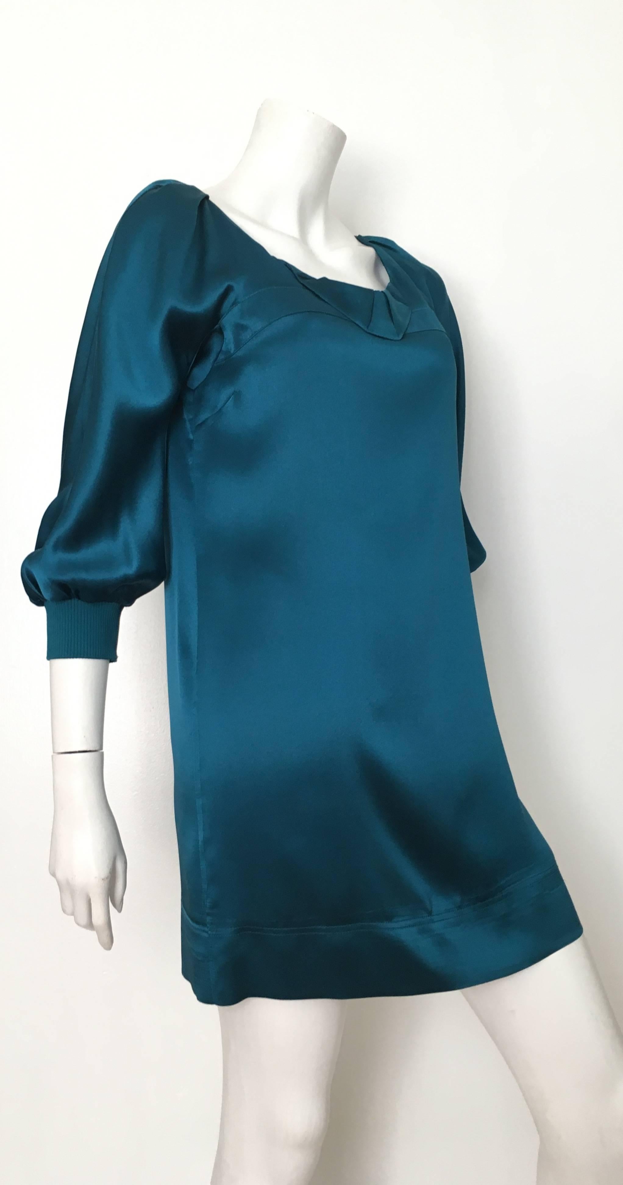 See by Chloe teal silk mini dress is a size 4. This gorgeous & sexy See by Chloe silk dress is a statement dress for just about any occasion. The knit band at sleeves provide you some versatility because you can adjust the length of sleeve to