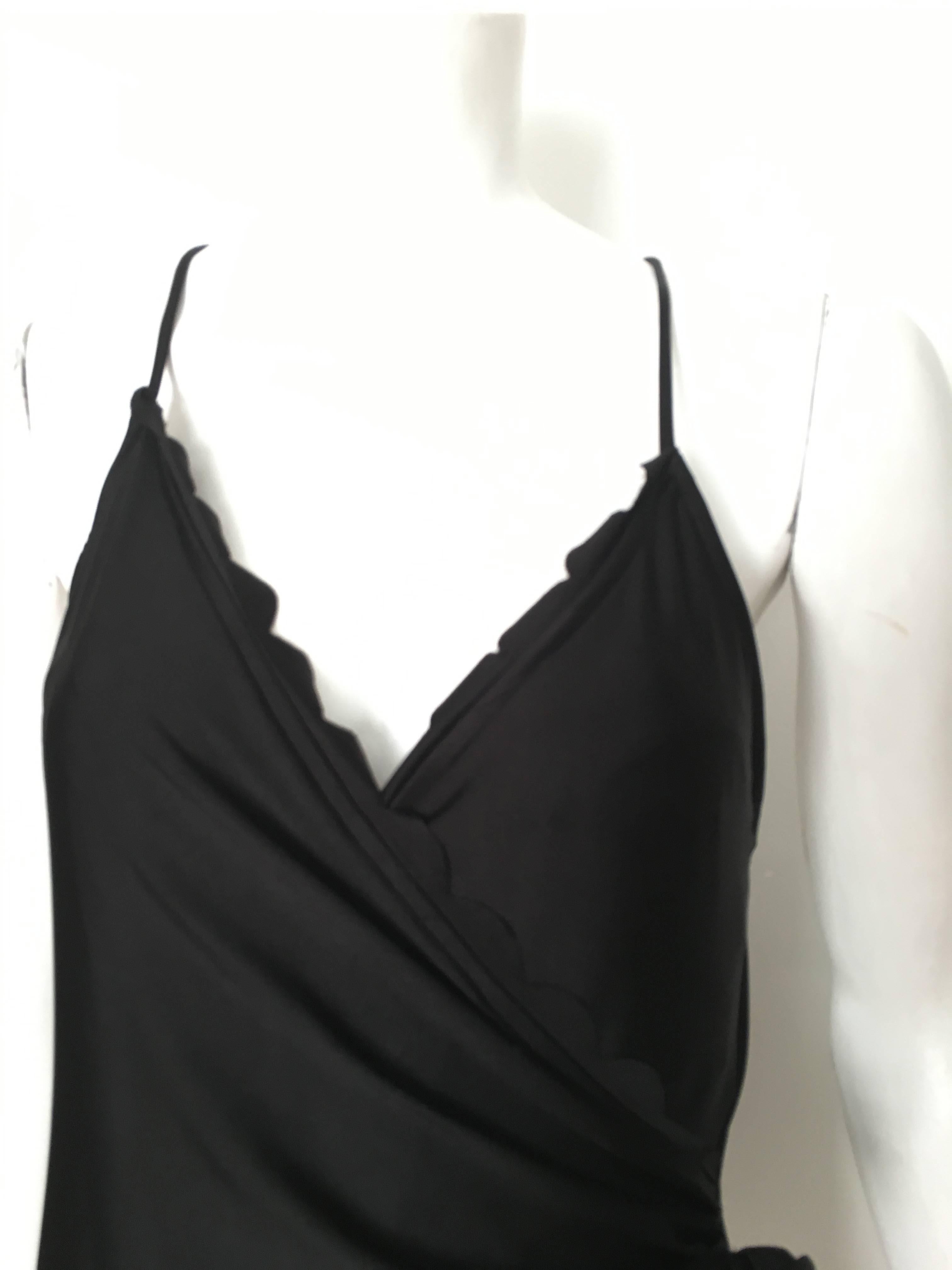 Oscar de la Renta 1990s black swimsuit crisscross back and flower on side is marked size 14 but fits more like a size 8/10. This is the perfect swimsuit for the woman that vacations in St. Tropez or St. Barts. Use your vintage Hermes large scarf as