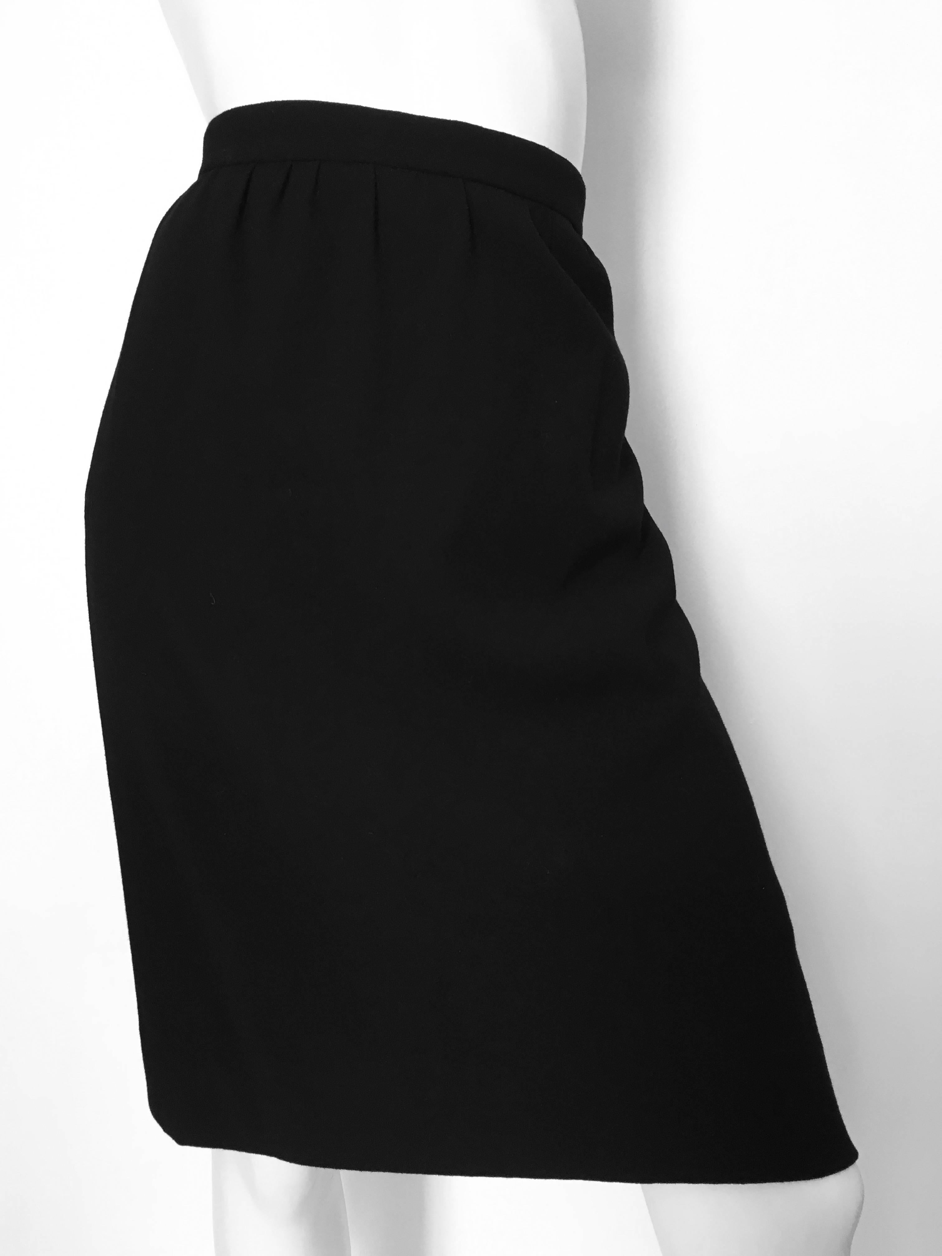 Chanel 1980s black wool skirt with pockets is a French size 44 and fits like an USA size 12. Has the iconic gold elephant button on the back of skirt. Skirt is lined in black silk with the Chanel logo. 
Measurements are:
34-3/4