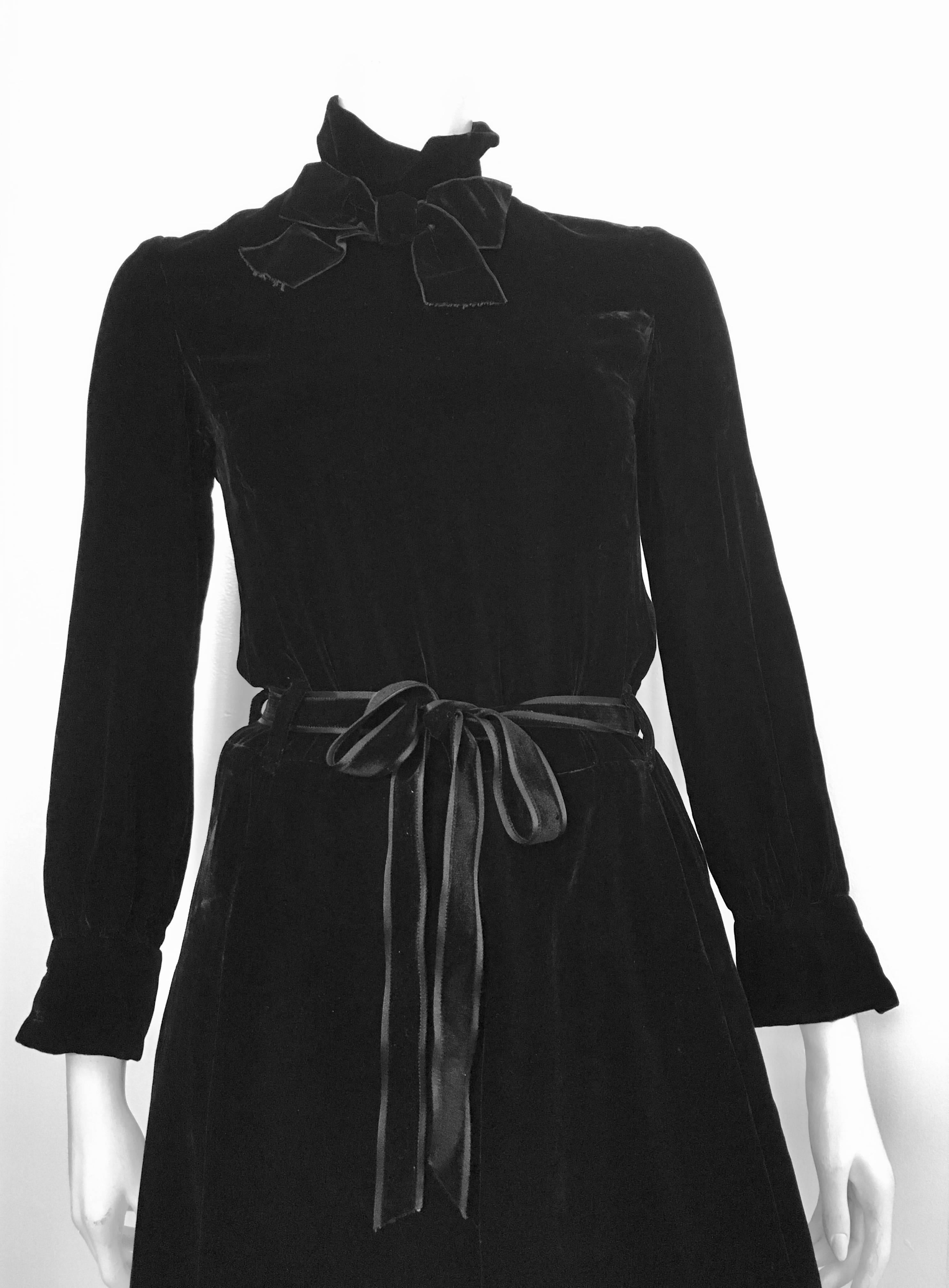 Christian Dior Prêt-a-Porter made exclusively for New Zealand El-Jay black evening velvet dress with bow at collar & velvet belt is a size 6.  Ladies please grab your most trusted friend, Mr. Tape Measure, so you can properly measure your bust,