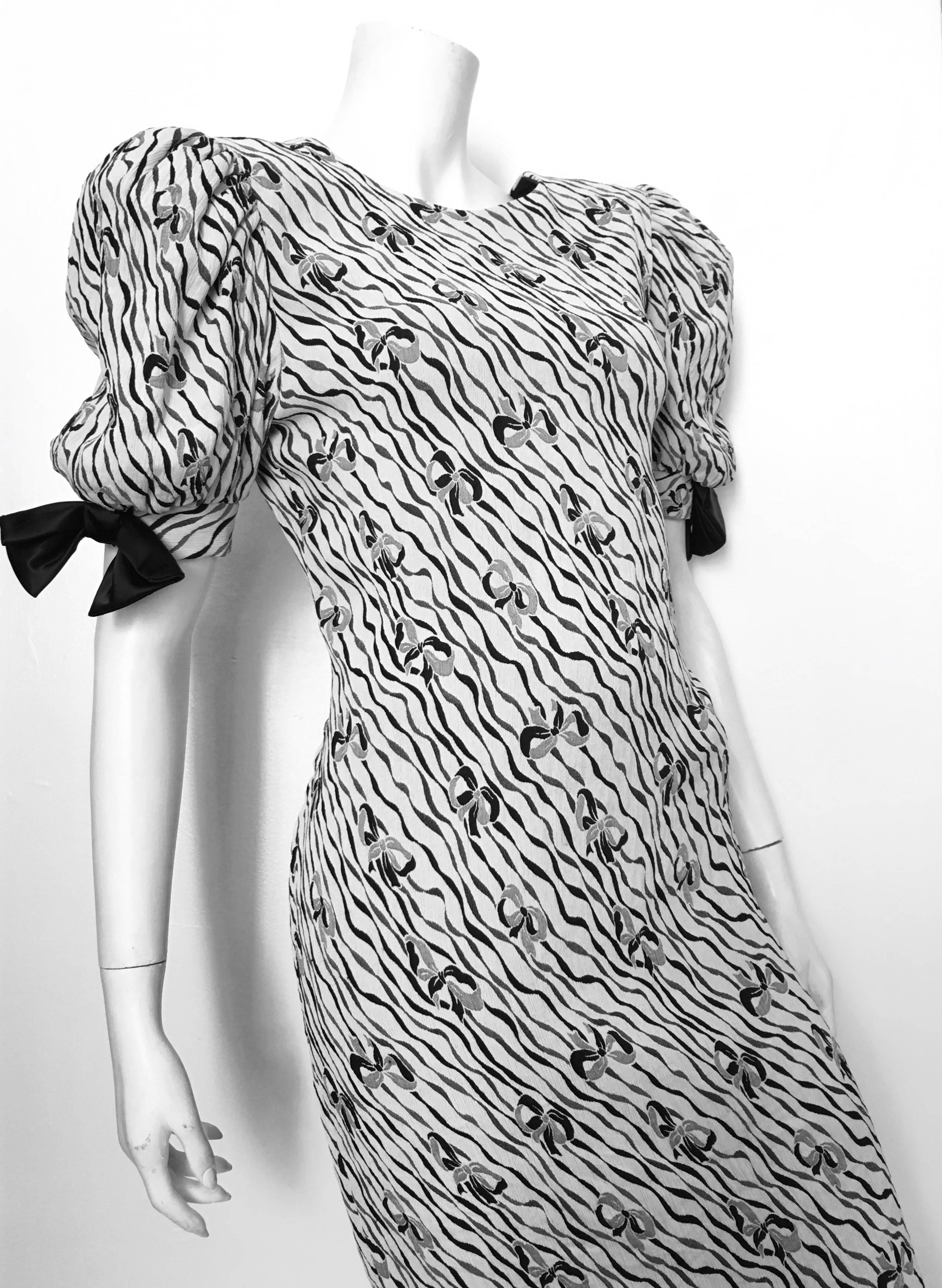 Pierre Cardin 1980s white background with black & grey squiggle lines and bow pattern stretch evening dress is labeled size 10. Ladies please grab your tape measure so you can measure your bust, waist, hips and length to see if this will fit your
