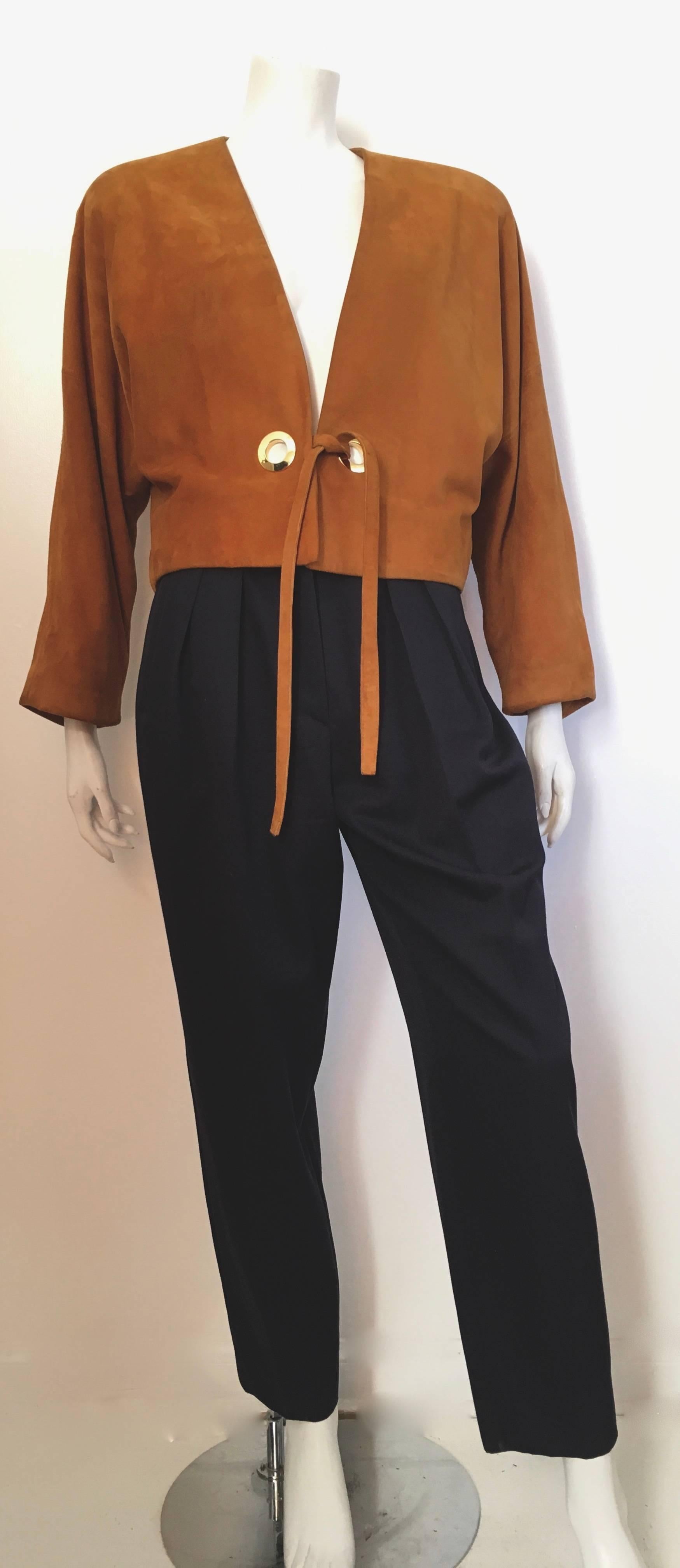 Anne Klein by Donna Karan 1980s tan suede bolero jacket is a size 10 /12. Gorgeous dolman sleeves with circle polished brass rings and ties. Jacket is lined and has shoulder pads. Classic bolero design suede jacket that can be worn with denim,