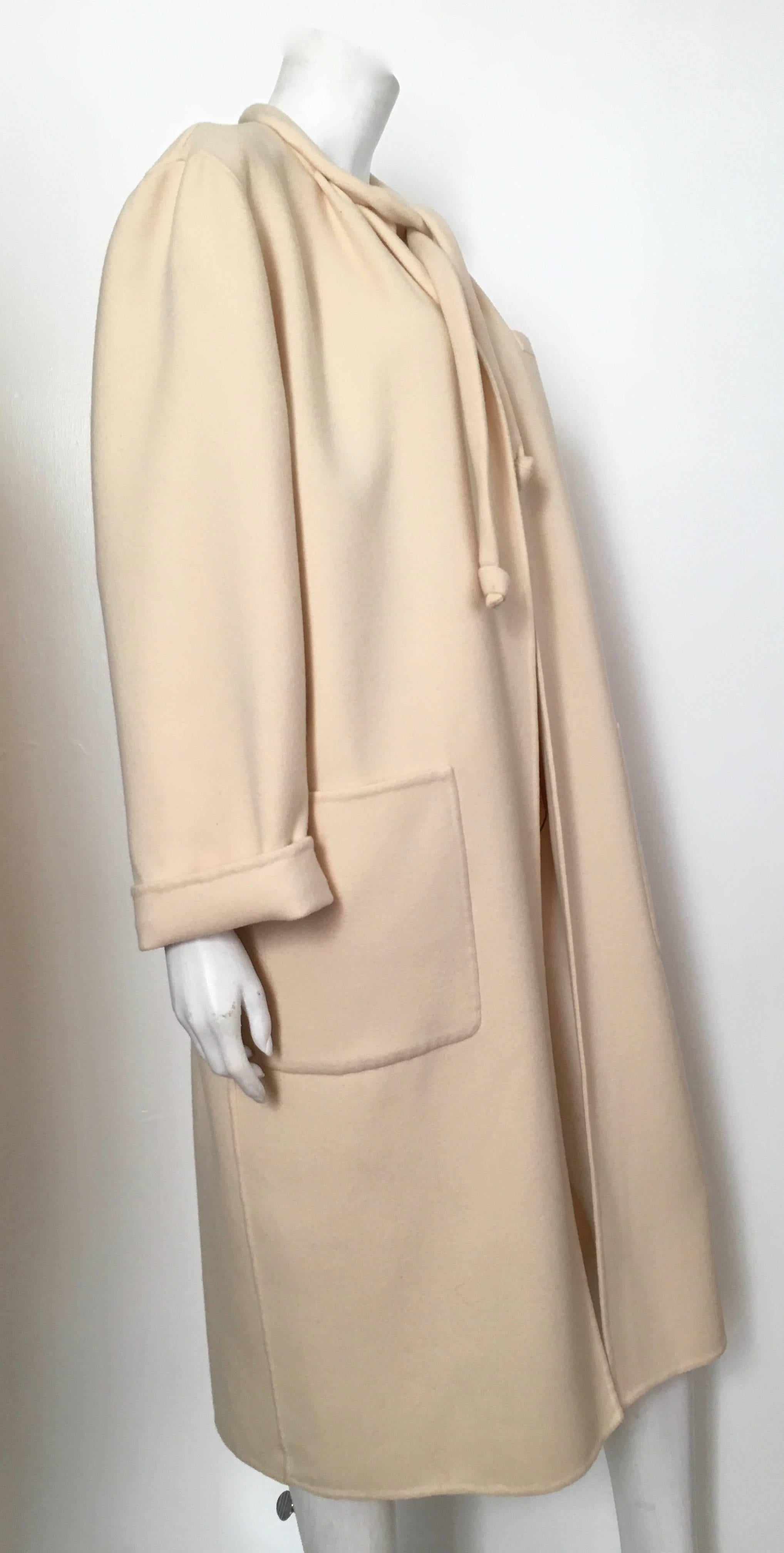 Salvatore Ferragamo for Neiman Marcus cream wool cocoon coat with large front pockets and tie string is a size 10. This absolutely stunning cream Ferragamo cocoon coat is just what the red carpet ordered. Stylish and forever chic this coat will have