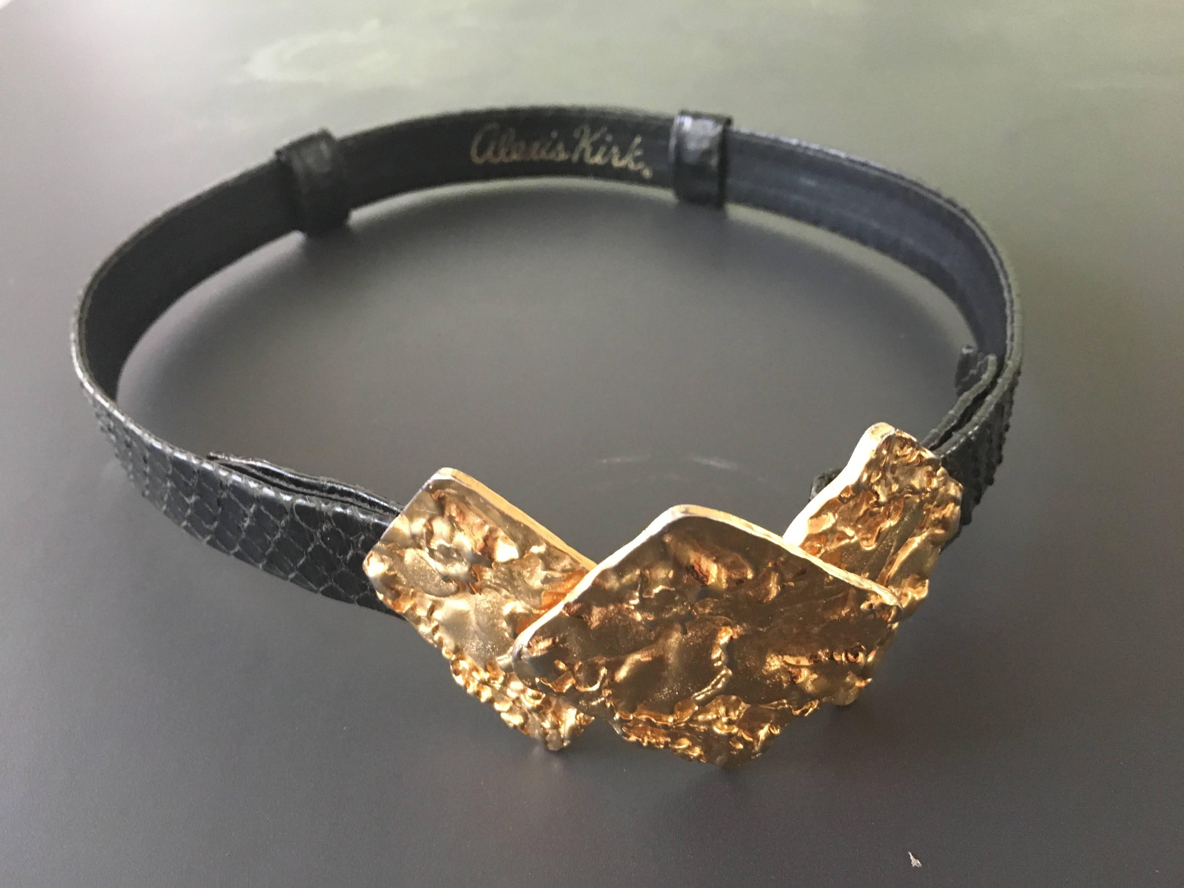 Alexis Kirk 1980s gold abstract buckle with black snake skin adjustable belt. This is the only belt you will ever need to own because it goes with jeans, skirts & dresses. On a scale from 1-10 this is off the chart. 
Measurements
