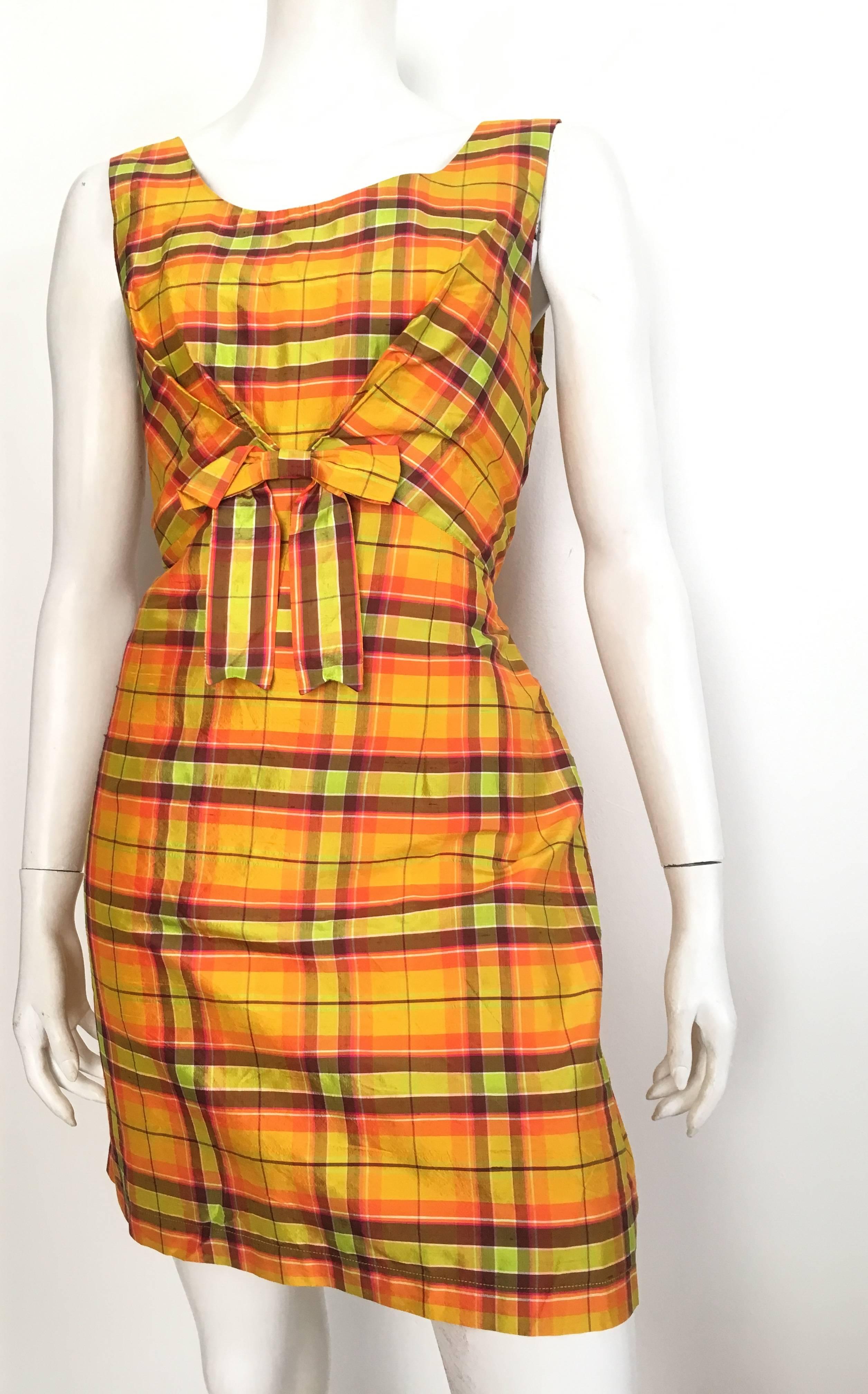 Moschino Jeans 1990 silk plaid sleeveless dress with front bow is labeled a USA size 12 but fits more like a size 10.  The waist on this dress is 31.1/2" so please grab your tape measure so that you can measure your bust, waist & hips to