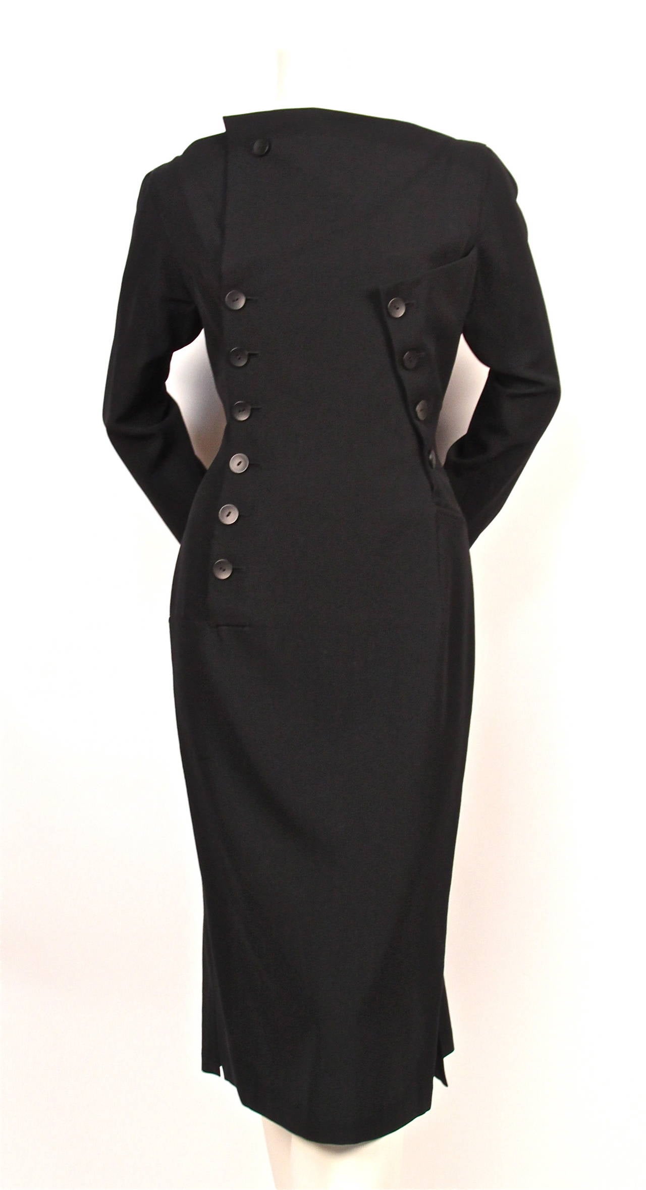 Jet black wool gaberdine dress with unusual asymmetrical button closure from Yohji Yamamoto dating to the 1980's. Dress is labeled a size 'S'. Approximate measurements: shoulder 16